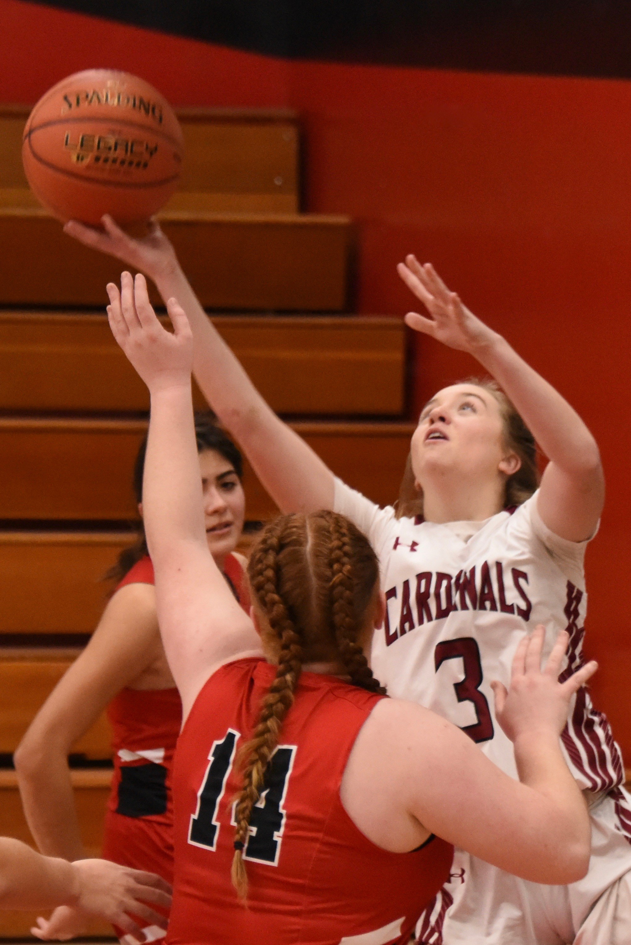 Clear Lake's Sierra Bruch reaches out for the rebound against St. Helena. Bruch scored eight points in the Cardinals' 65-12 victory. (Photos courtesy of Trett Bishop)