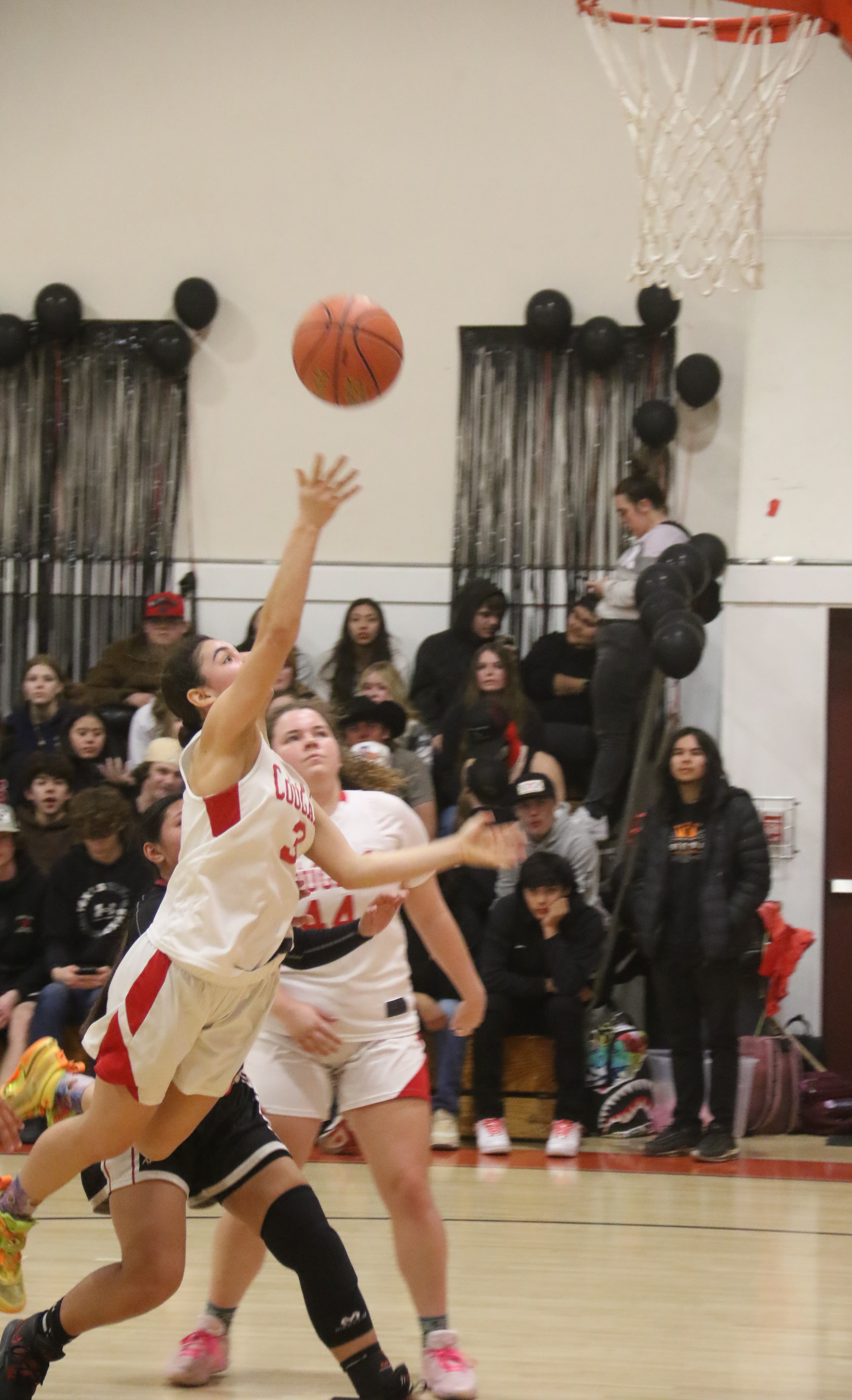 A fully extended Maddy Young underhands a shot as teammate Kali Minnis looks on. (Photos by Minenna Photography)