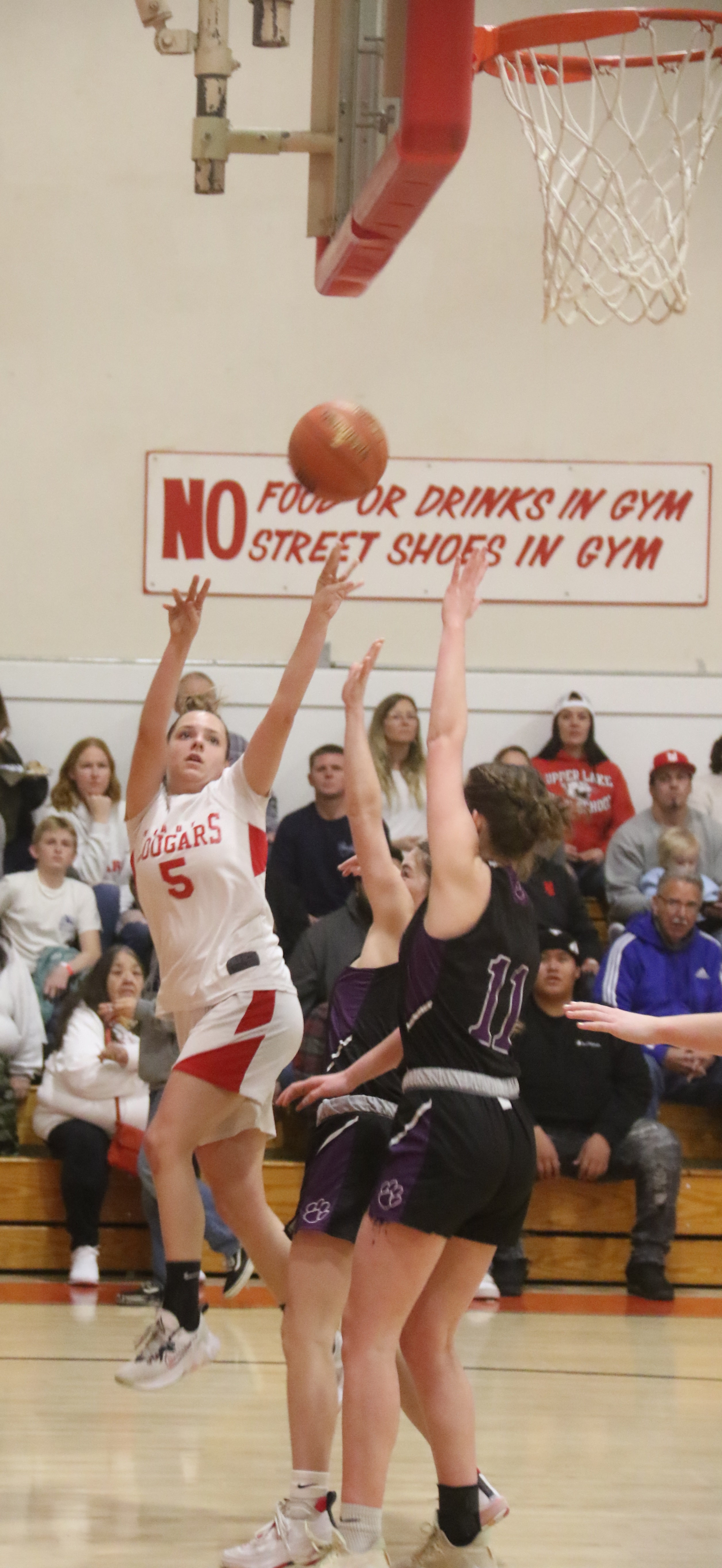 Jayme Zimmerschied releases a shot in front of two Portola defenders, including center Emily Hughes (11). Zimmerschied finished with nine points in Upper Lake's 52-47 win. (Photos by Minenna Photography)