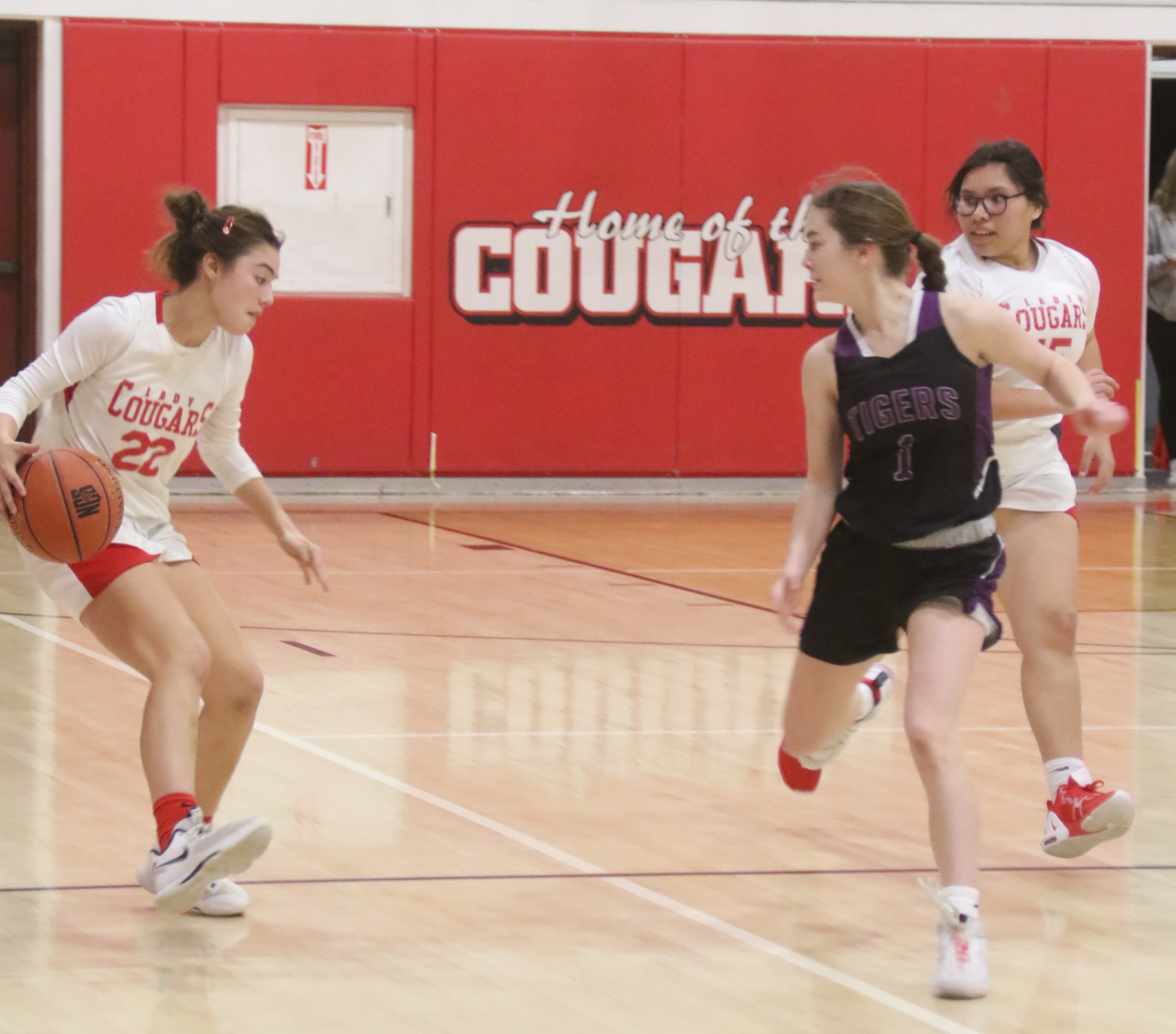 Upper Lake's Nya Marcks brings the ball across half court as Portola's Clara Klemesud defends. Following the action is Upper Lake's Lupe Monlo-Duncan. (Photos by Minenna Photography)