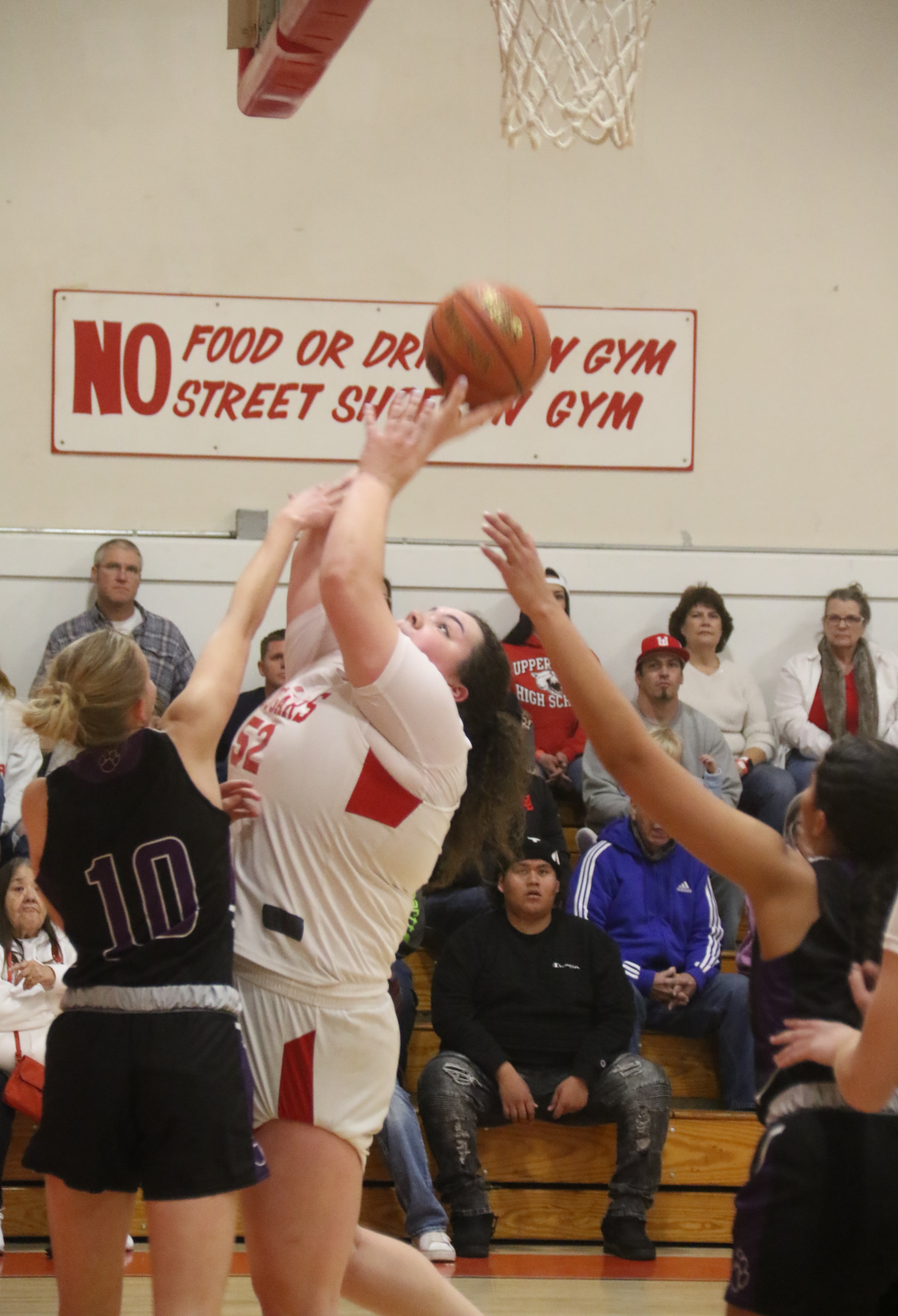 Upper Lake's Taylar Minnis muscles up a shot despite pressure from Portola defender Peyton Wicks. Minnis finished with 11 points in the Cougars' 52-47 win over the Tigers. (Photos by Minenna Photography)