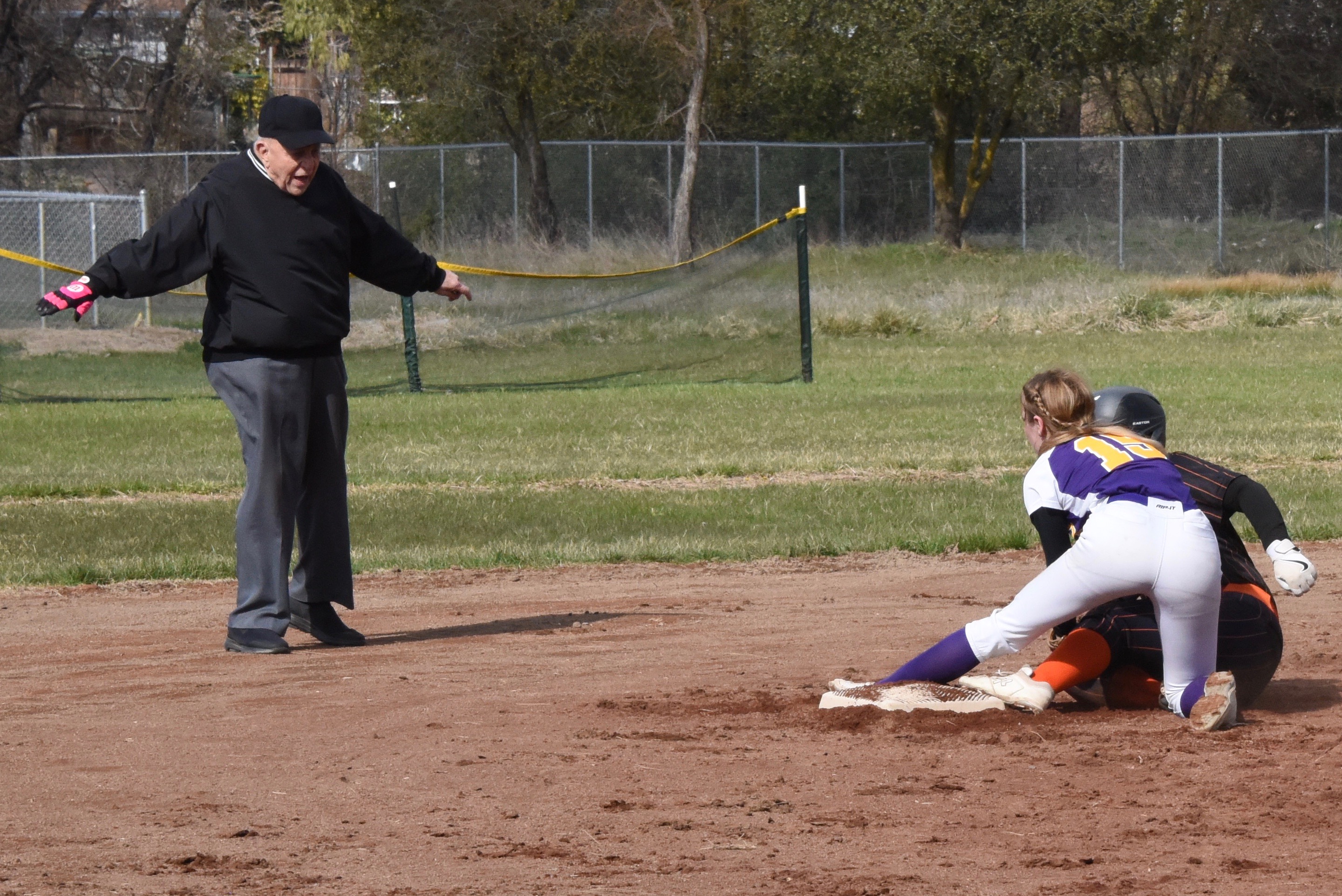 Base umpire Dave Harkavey calls Ogo safe as Holley looks on. (Photos courtesy of Trett Bishop)