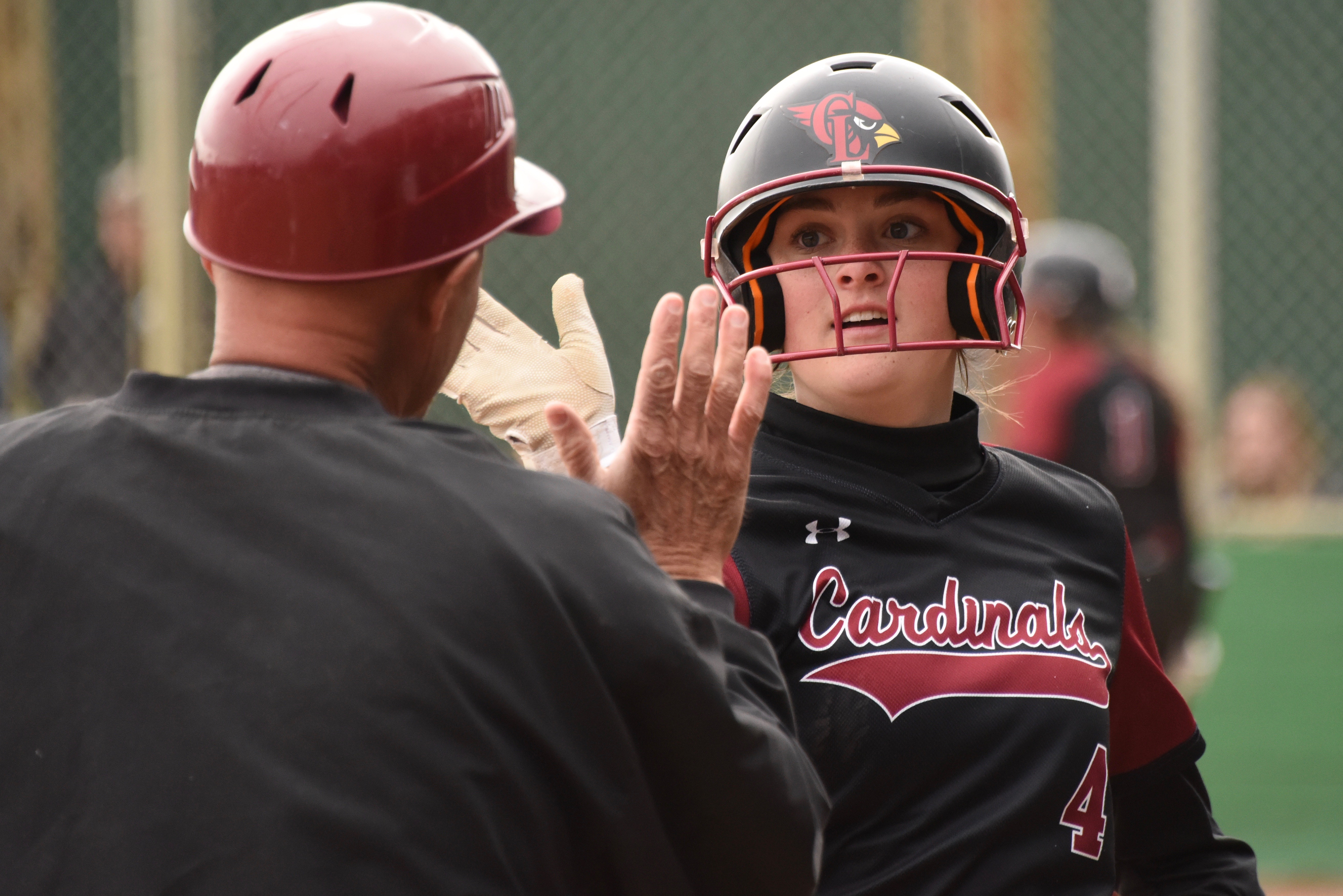 Clear Lake assistant coach Phil Psalmonds exchanges high-fives with Montana Wells on Monday afternoon in Lakeport, Wells drove in a pair of runs in the Caridnals' 13-4 league win over Kelseyville. (Photos courtesy of Trett Bishop)