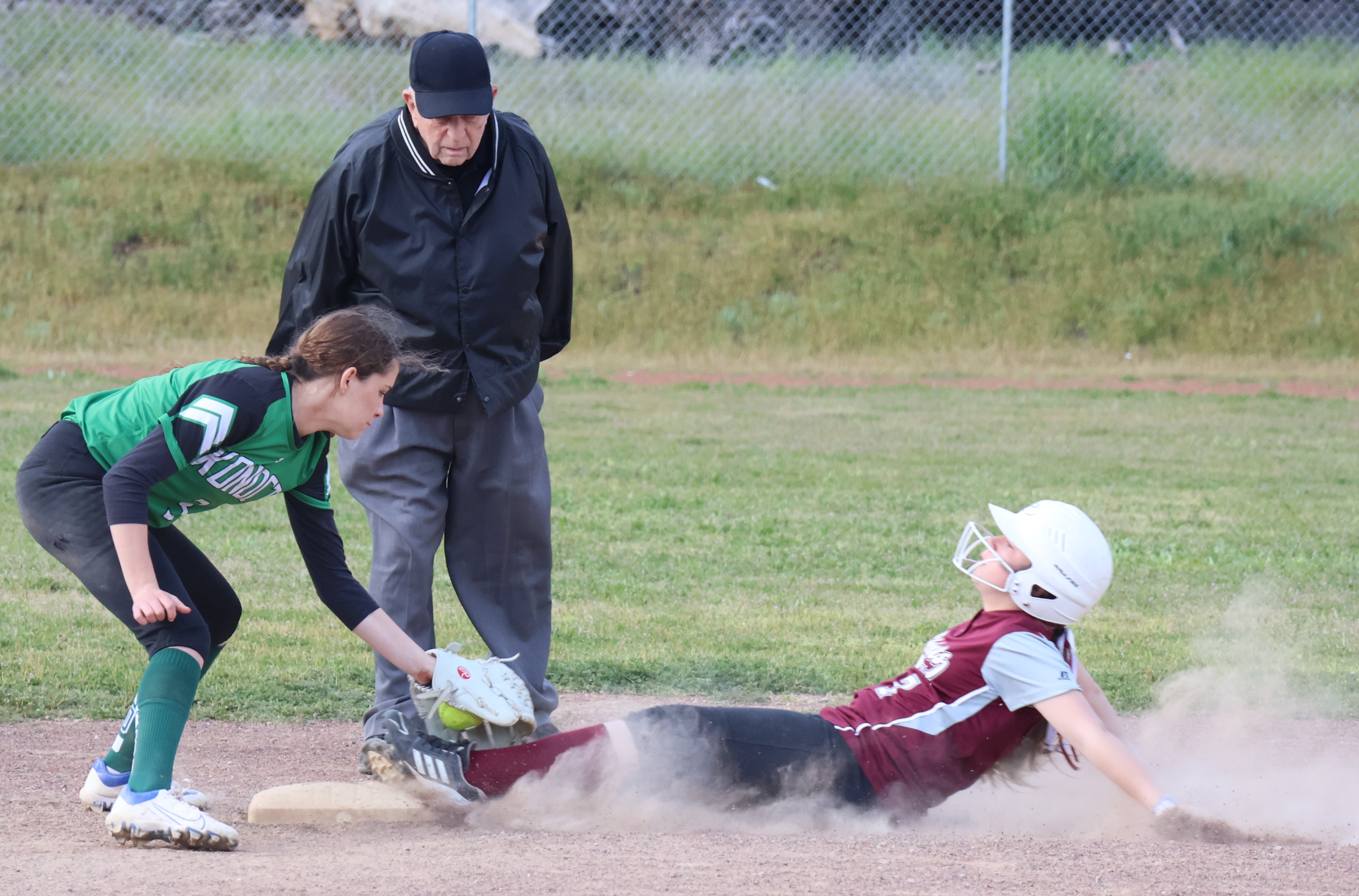 Upper Lake's Madi Byrne slides safely into second base, just ahead of the tag of Konocti shortstop Aly Aguirre as base umpire Dave Harkavey looks on. (Photos by Brian Sumpter)