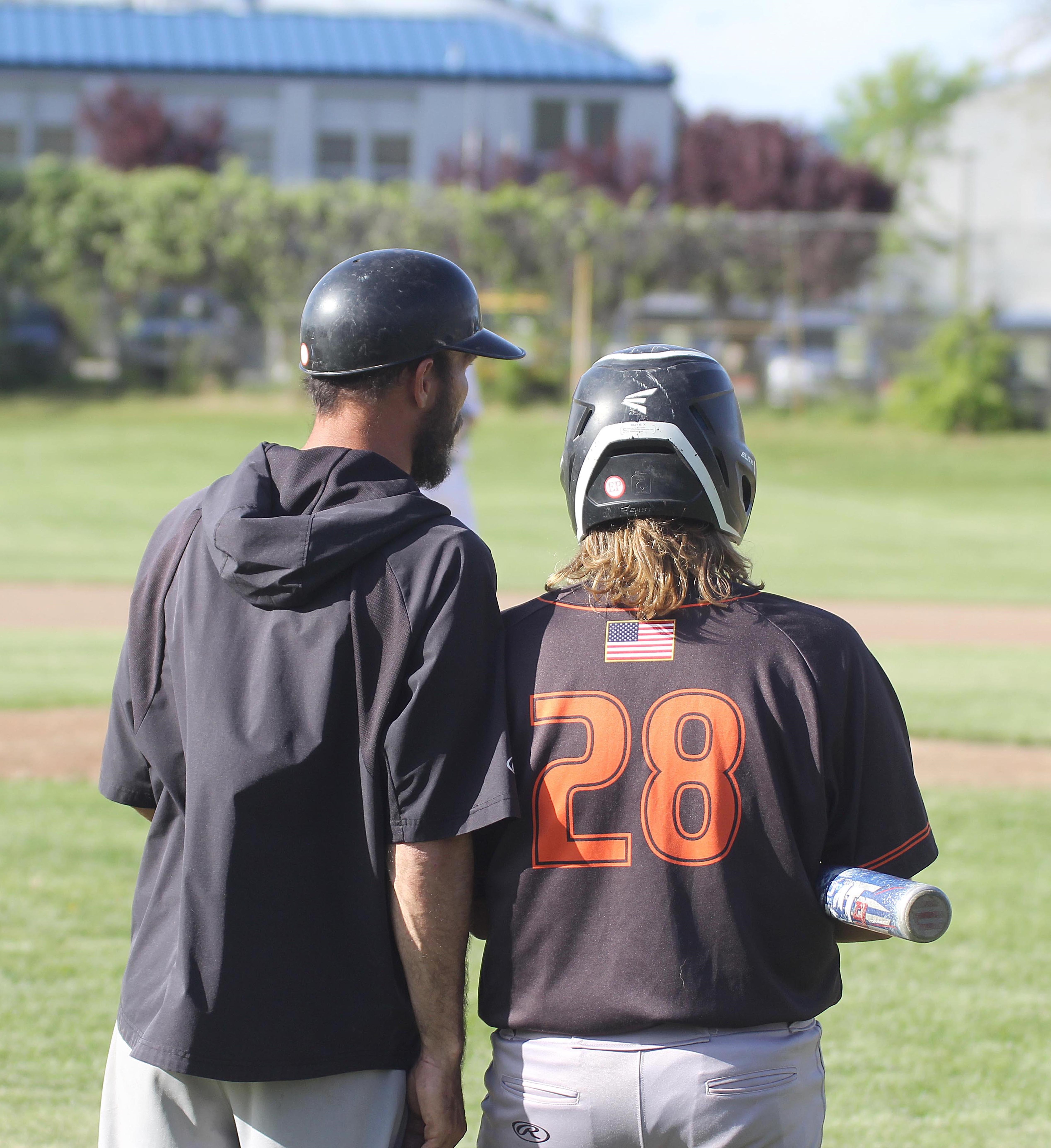Kelseyville head coach Billy Shaul and player Jon Dougherty talk things over prior to Dougherty's at-bat against Lower Lake. He went 1-for-4 with two RBIs in the Knights' 10-1 victory. (Photos by Minenna Photography)