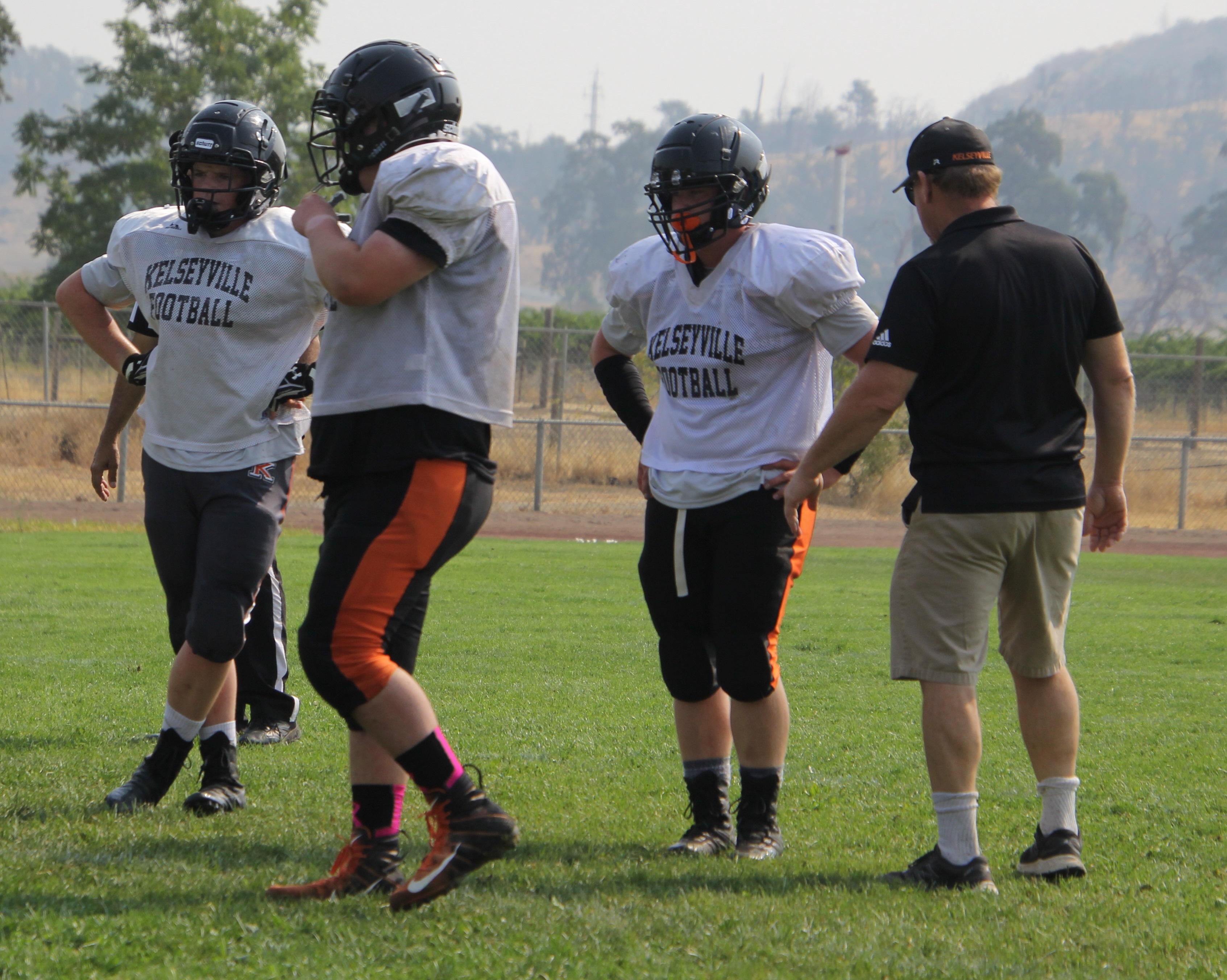 Former Kelseyville High School varsity football head coach Erick Larsen works with Knights players during the Lake County Scrimmage. Larsen, Kelseyville's head coach for eight seasons, is leaving to take over the St. Helena High School football program. (File photos)