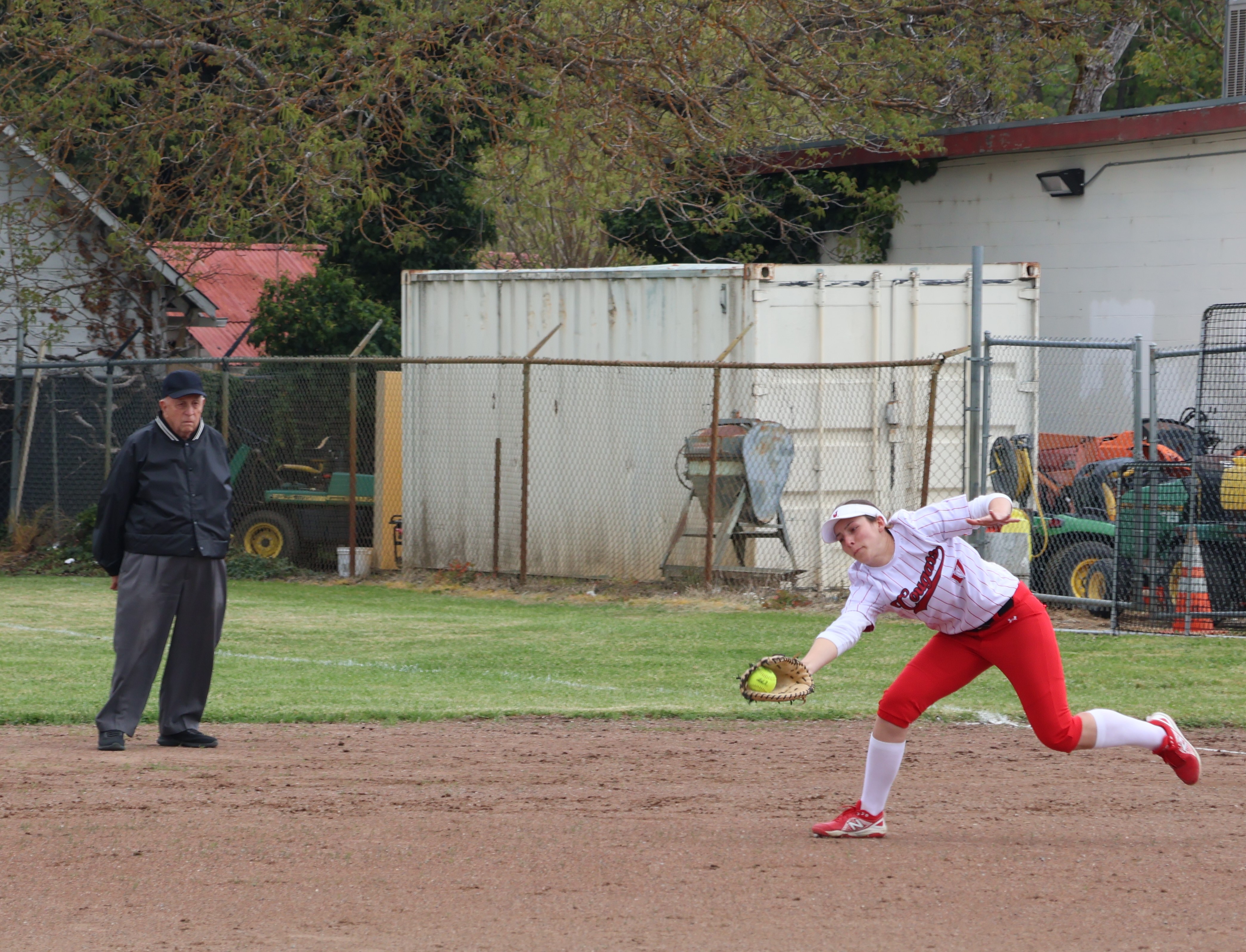 As base umpire Dave Harkavey looks on, Upper Lake first baseman Paris Klier stretches out to haul in a soft line drive for the out. (Photos by Brian Sumpter)