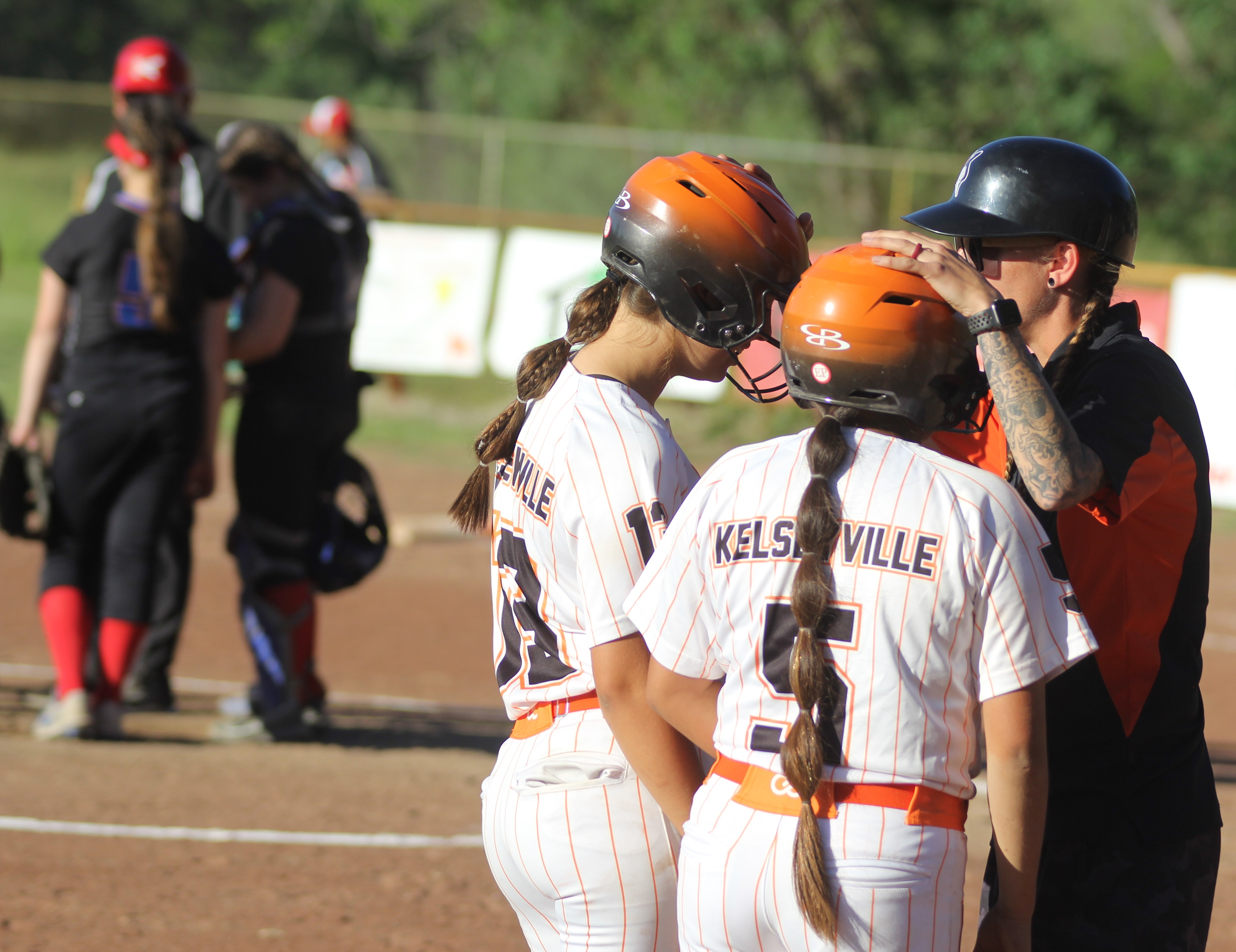 Kelseyville head coach Julie Jackson huddles with Cali Schnabl (left) and courtesy runner Pasalo in the bottom of the sixth inning as Swett head coach Steve Millan meets with his pitcher, daughter Rebekah Millan, during a break in the action. Kelseyville put runners at second and third with no outs but couldn't score in a 6-4 first-round playoff loss Tuesday afternoon in Kelseyville. (Photos by Minenna Photography)