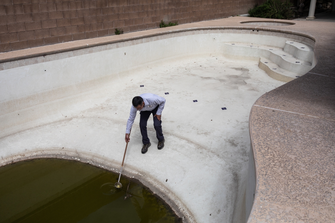 Rick Alvarez inspects abandoned swimming pool
