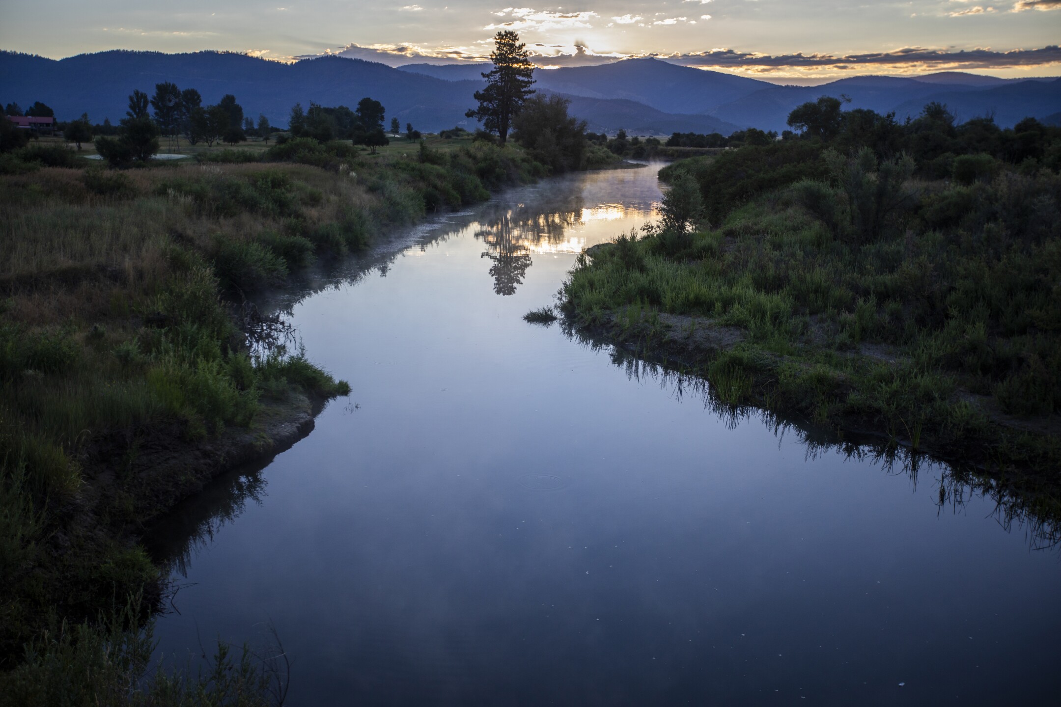 At dawn, steam rises from calm Indian Creek between Crescent Mills and Taylorsville. When one leaves the burn scar, the landscape returns to color.