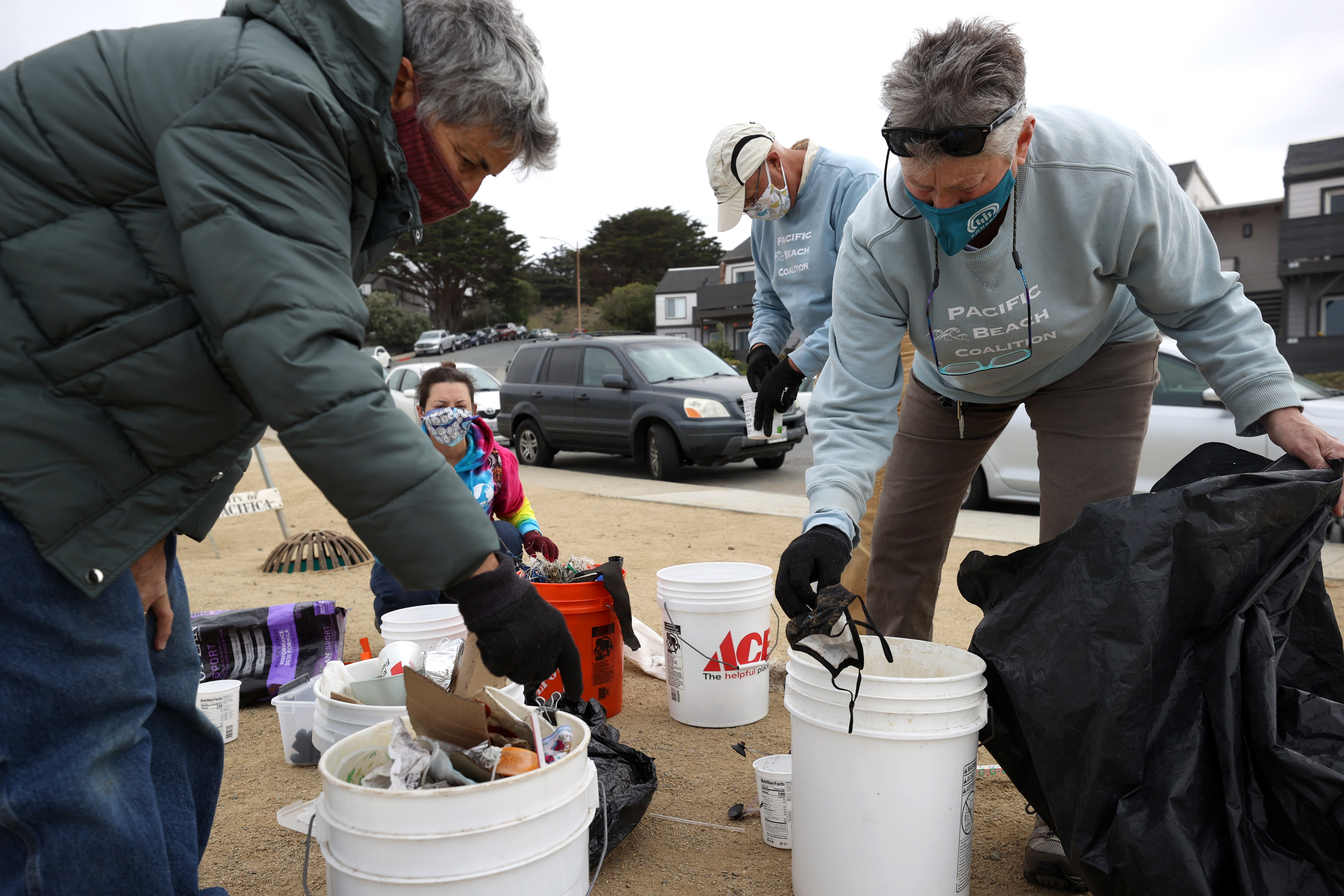 Pauline Taini, left, and Lynn Adams, volunteers with Pacific Beach Coalition, sort through trash they collected near Pacifica Esplanade Beach on April 3, 2021 in Pacifica, Calif.