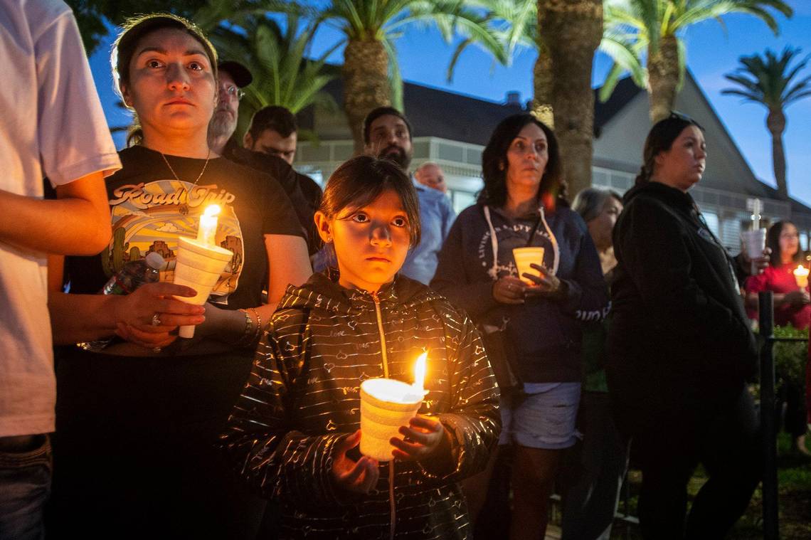 Monserrat Herrera, 8, of Merced, center, her mother Yubicela Sanchez, left, and her brother Christopher Herrera, 17, hold candles during a vigil for 8-month-old Aroohi Dheri, her parents Jasleen Kaur, 27, and Jasdeep Singh, 36, and her uncle Amandeep Singh, 39, at Bob Hart Square in Merced, Calif., on Thursday, Oct. 6, 2022.