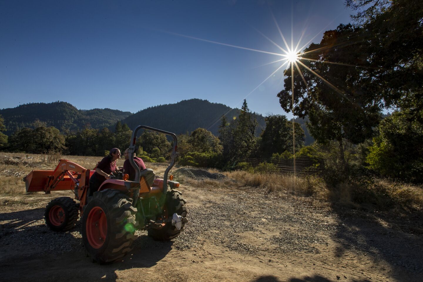Partners Wendy Kornberg, left, and James Beurer, right, lean in for a kiss on their farm near Garberville, Calif.