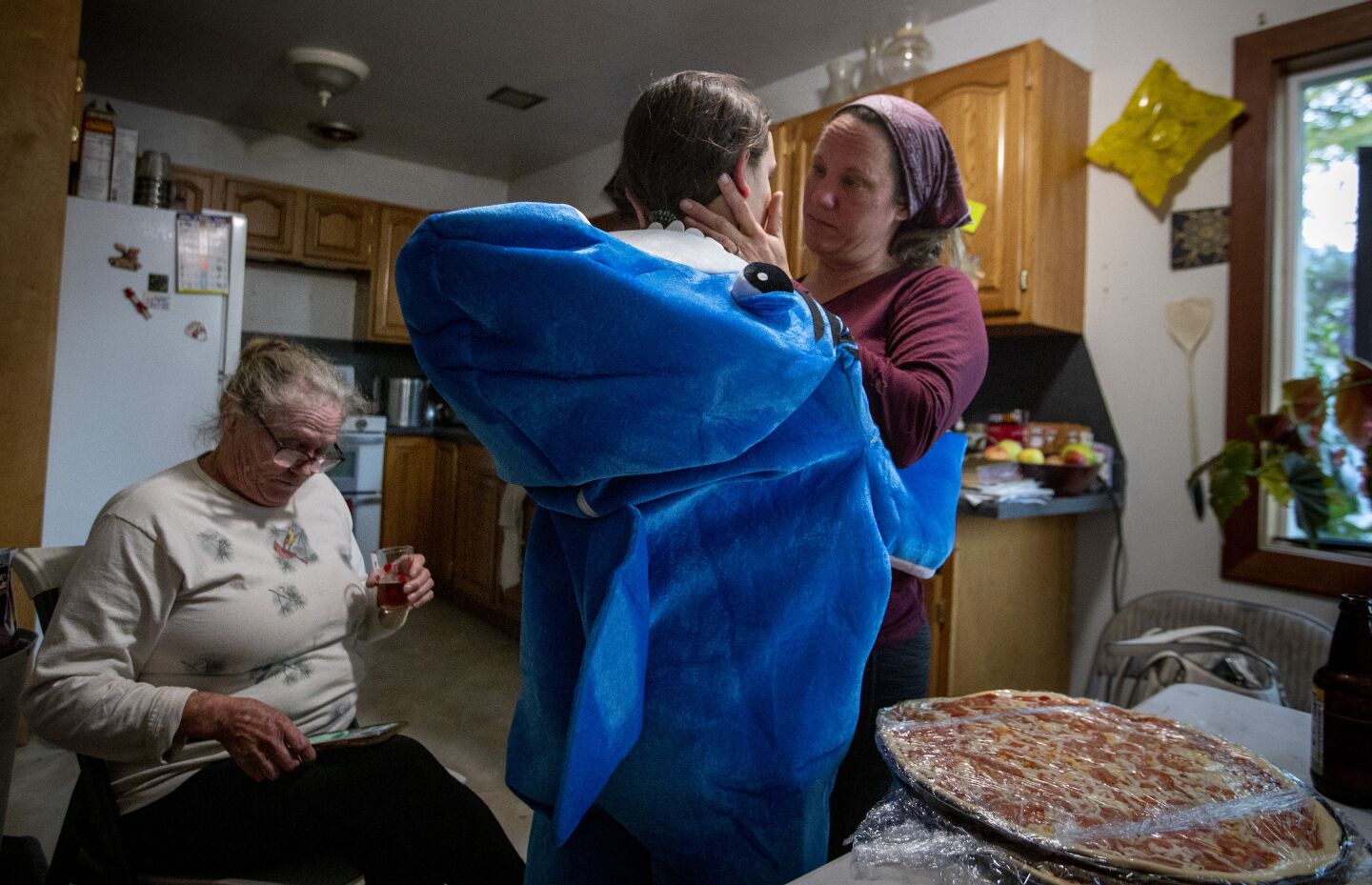 Wendy Kornberg comforts her daughter at their home after a long day harvesting cannabis.