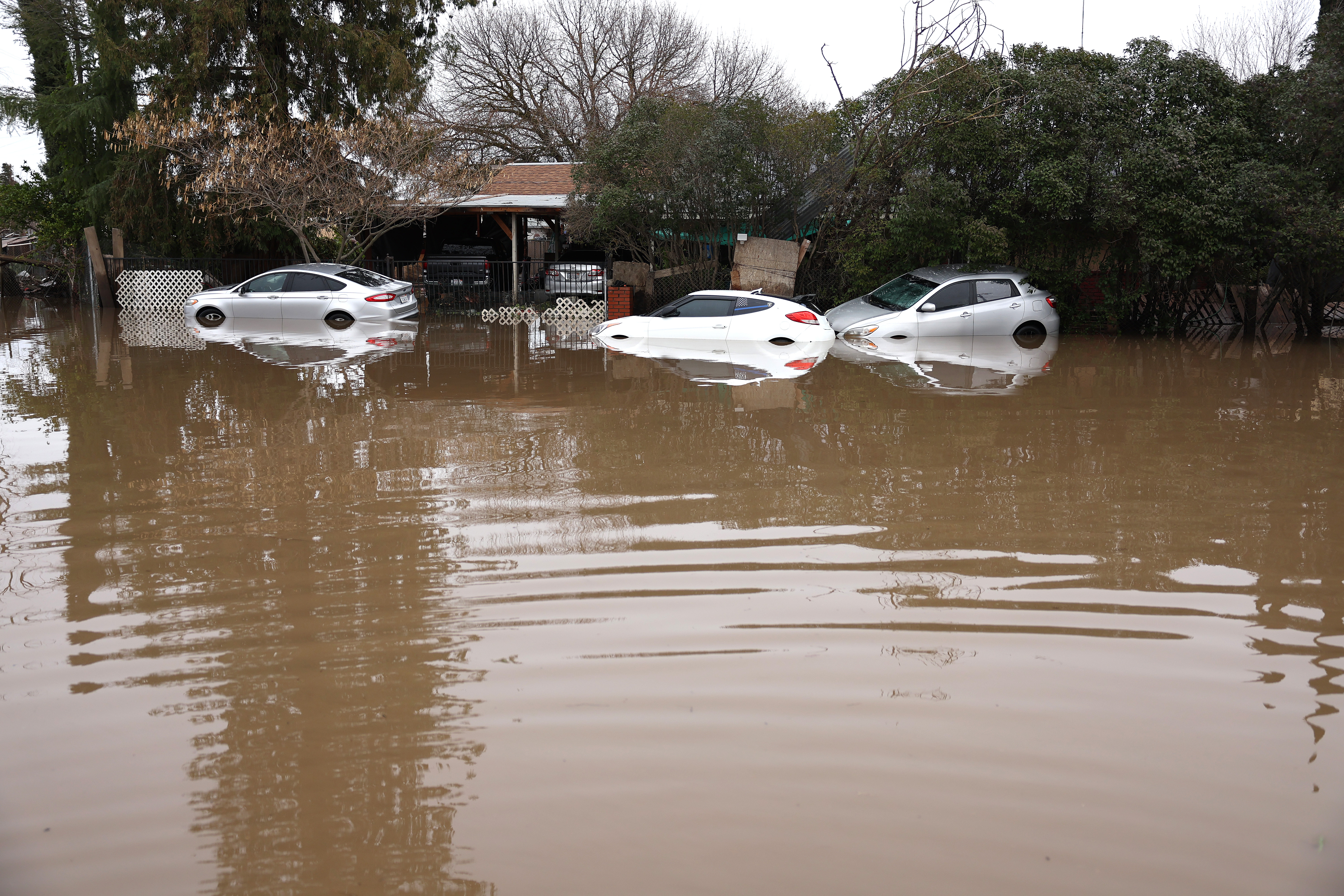 Cars sit in floodwaters on Jan. 11, 2023 in Planada, Calif.