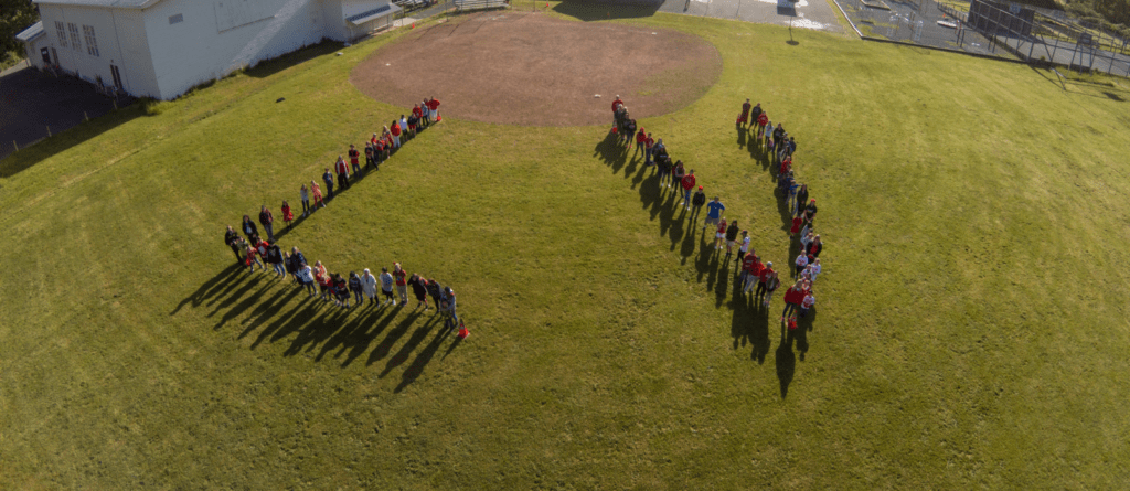 Students at Leggett Valley School spell out the school's initials on their field.