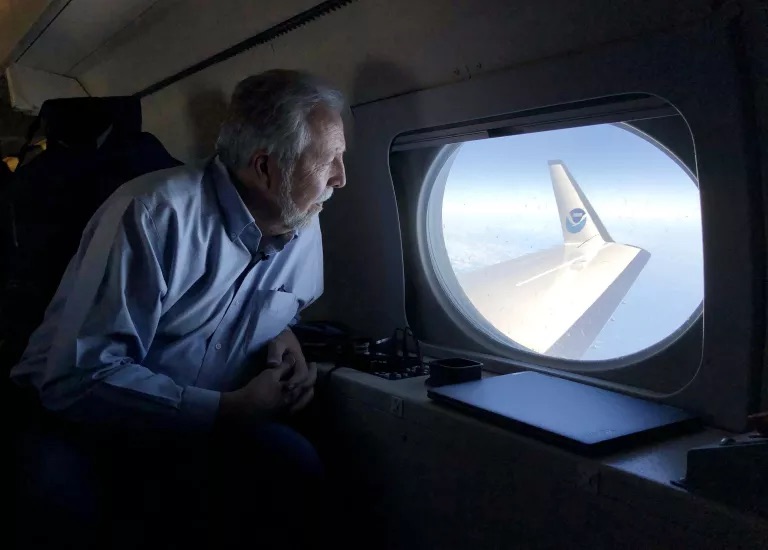 Meteorologist Marty Ralph, director of the Center for Western Weather and Water Extremes at Scripps Institution of Oceanography, looks out the window after flying to an atmospheric river northeast of Hawaii on a NOAA reconnaissance flight.