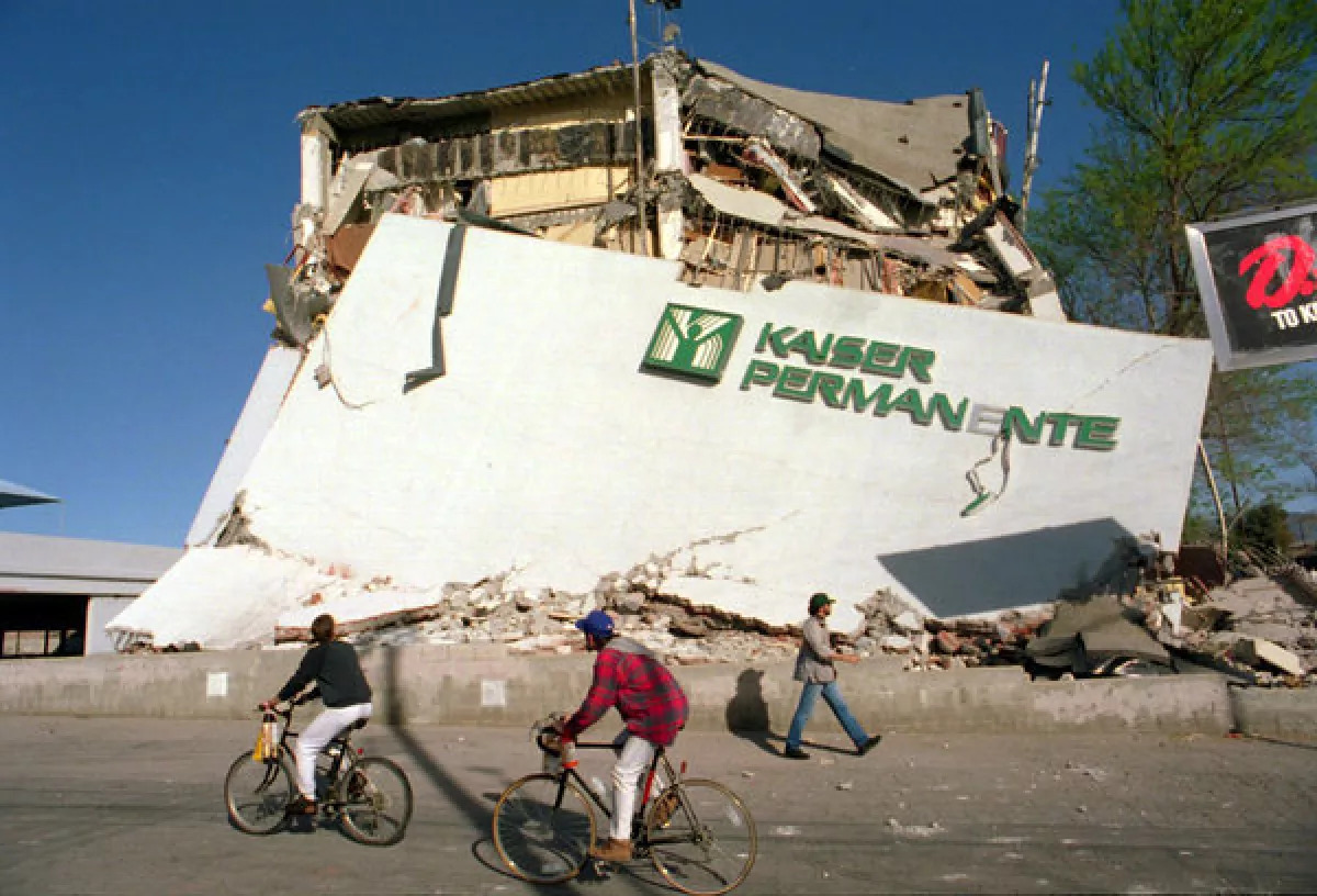 Cyclists roll past the remains of a collapsed Kaiser Permanente clinic and office building in the San Fernando Valley after the 1994 Northridge earthquake.