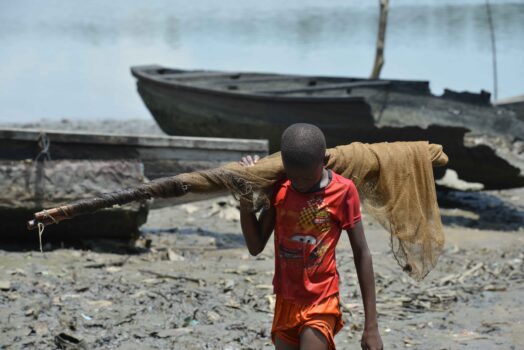 A young fisherman returns from fishing in Bodo, Ogoniland. With his net across his shoulder, the young lad looks downcast after coming back without any catch. Photo by Patrick Egwu