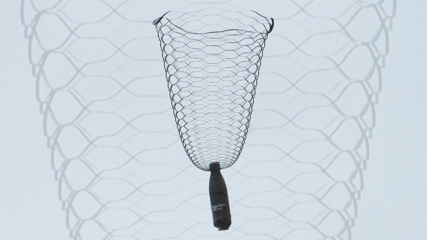 A water bottle dangles from a lacy, vase-shaped parachute.