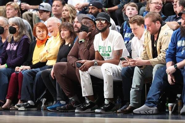 Tee Morant sitting courtside at a basketball game