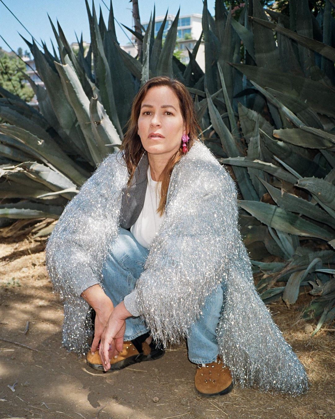 Franka Potente in a squatting pose