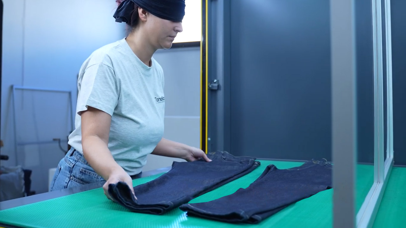 Figure: A blindfolded worker is placing garments on the laser machine