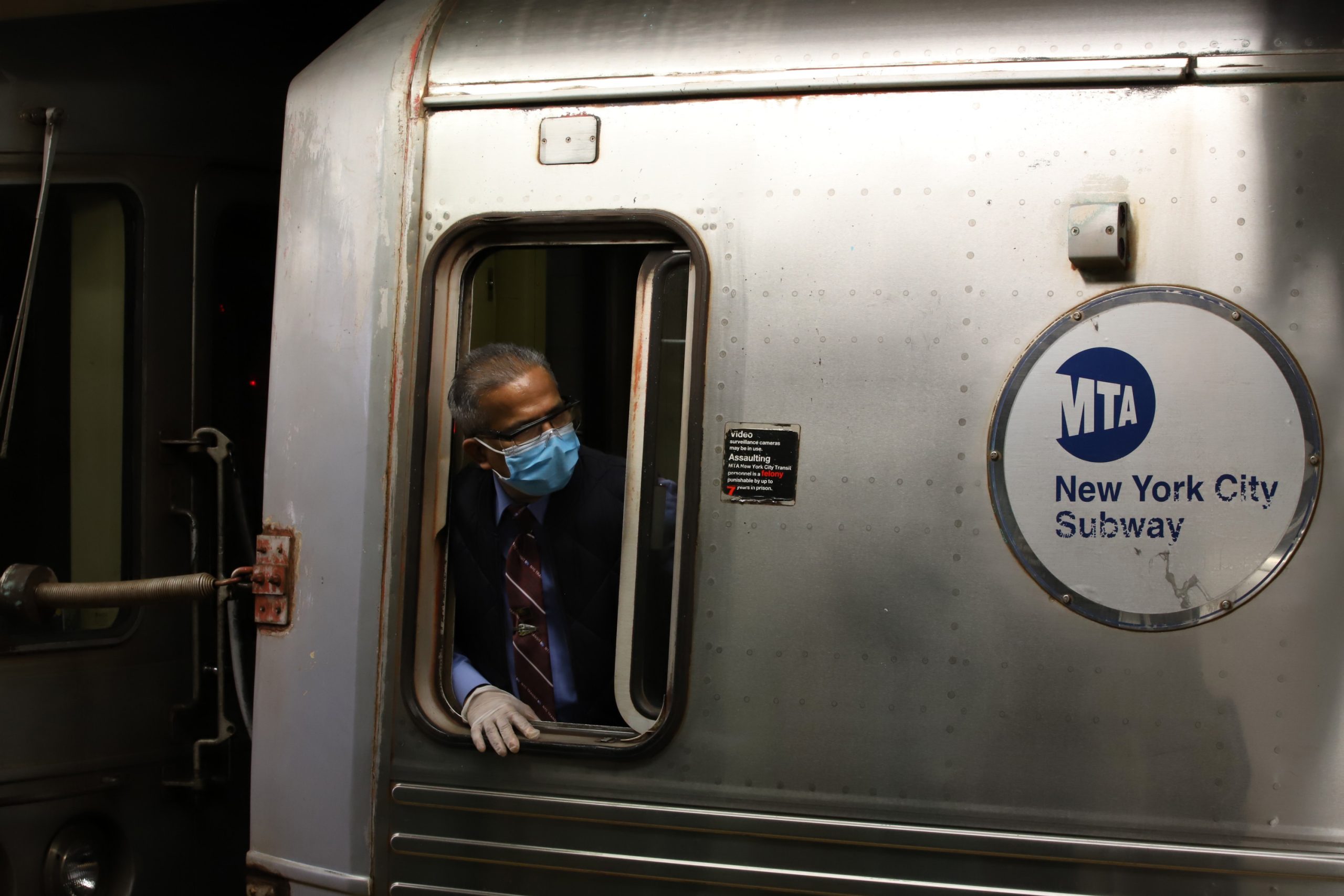 An MTA conductor checks the doors before their train leaves the station.