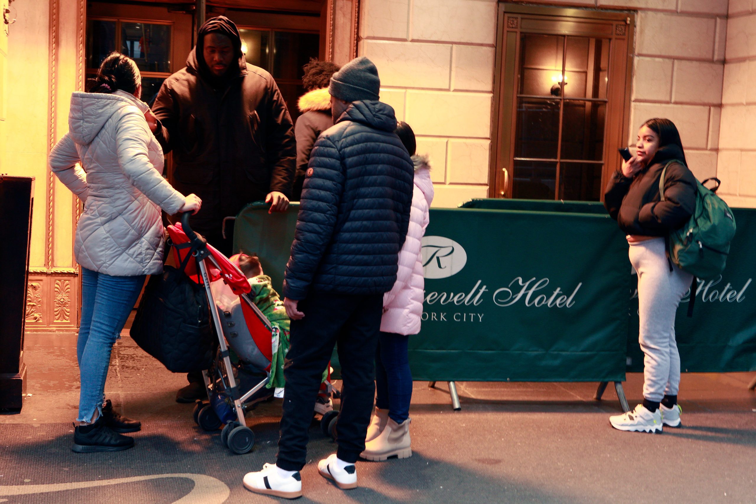 A family leaves the Roosevelt Hotel shelter as migrants began to receive eviction notices.