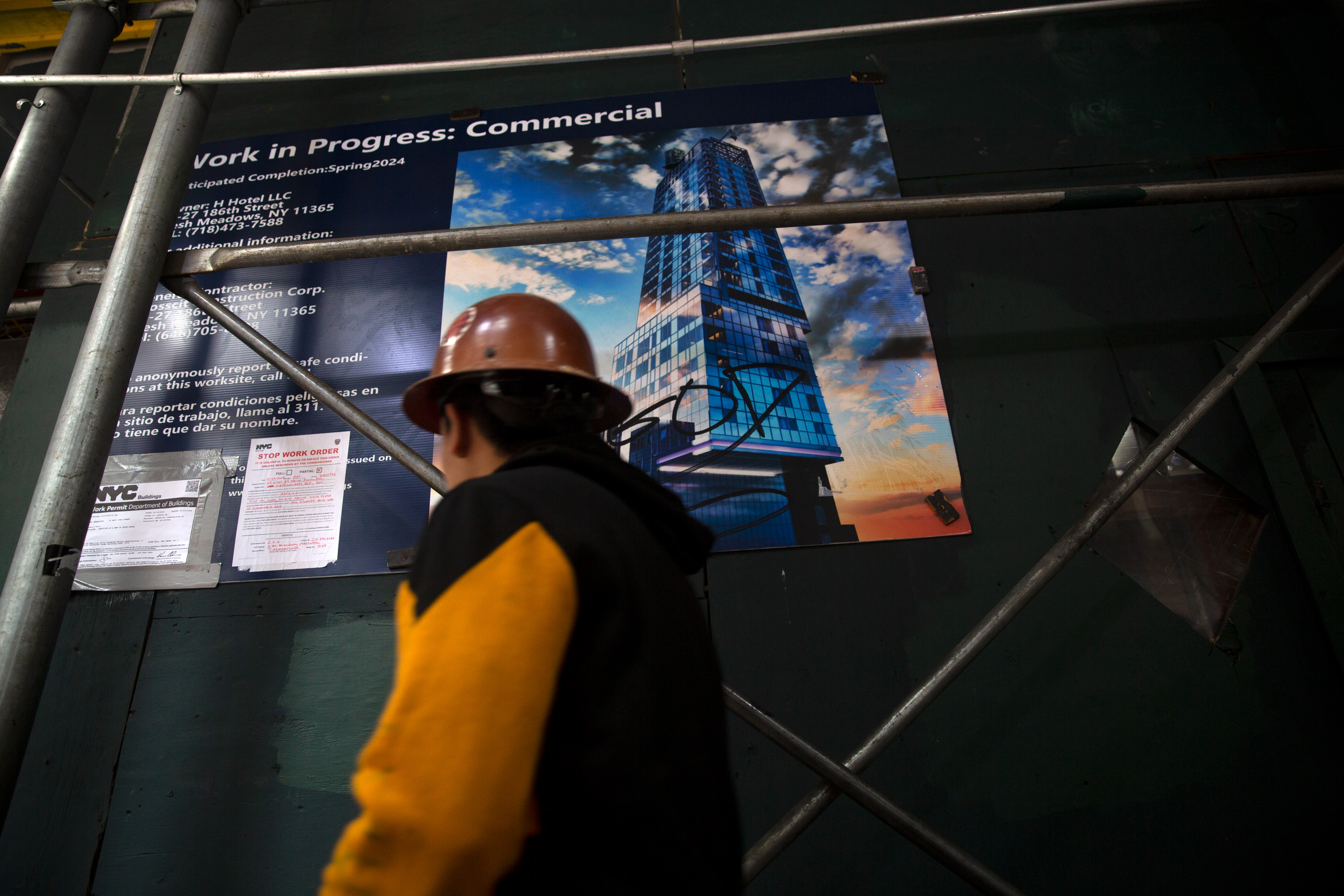 A construction worker at 58 W. 39th St. walks past a rendering fo the hotel development.