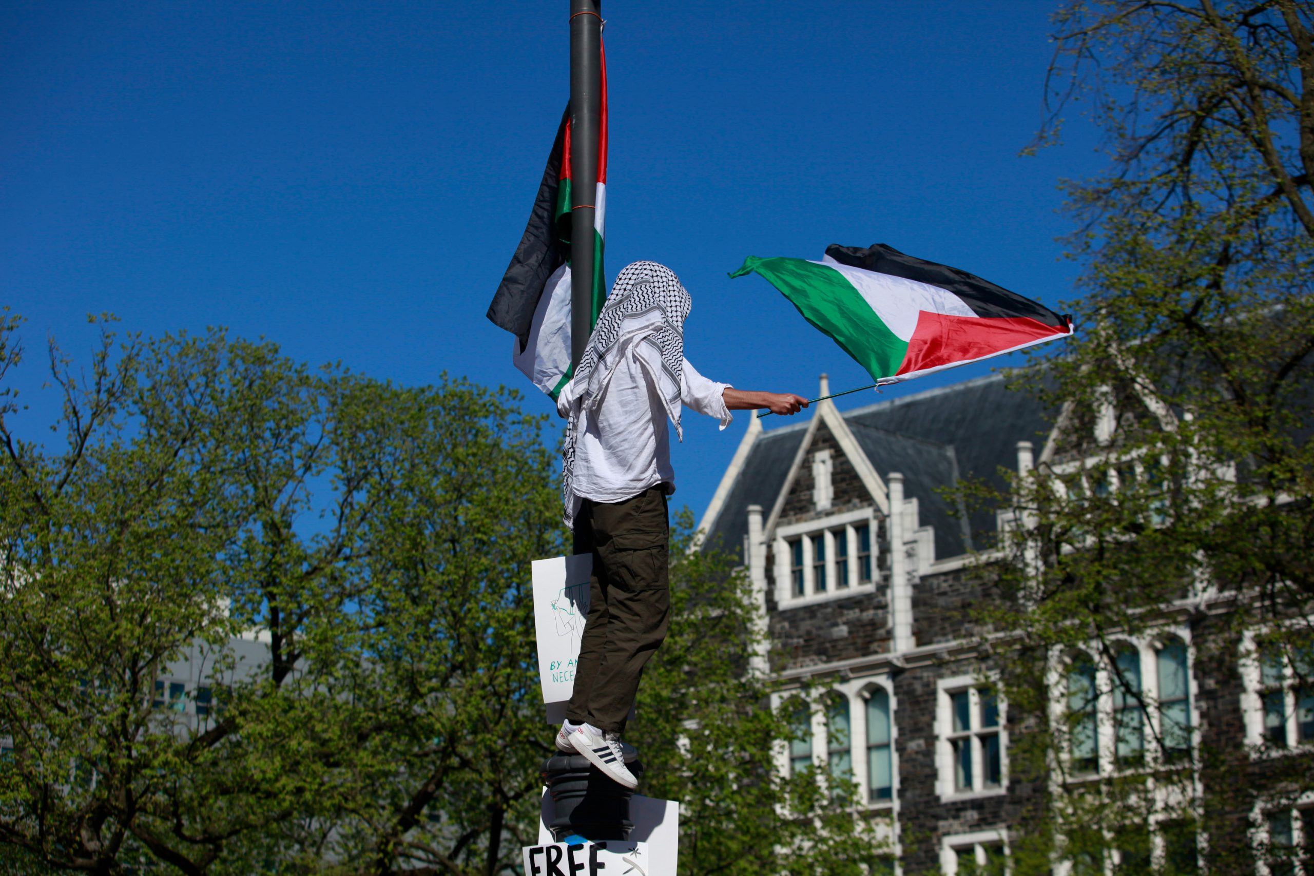 A protester waves flags at the pro-Palestinian encampment at City College