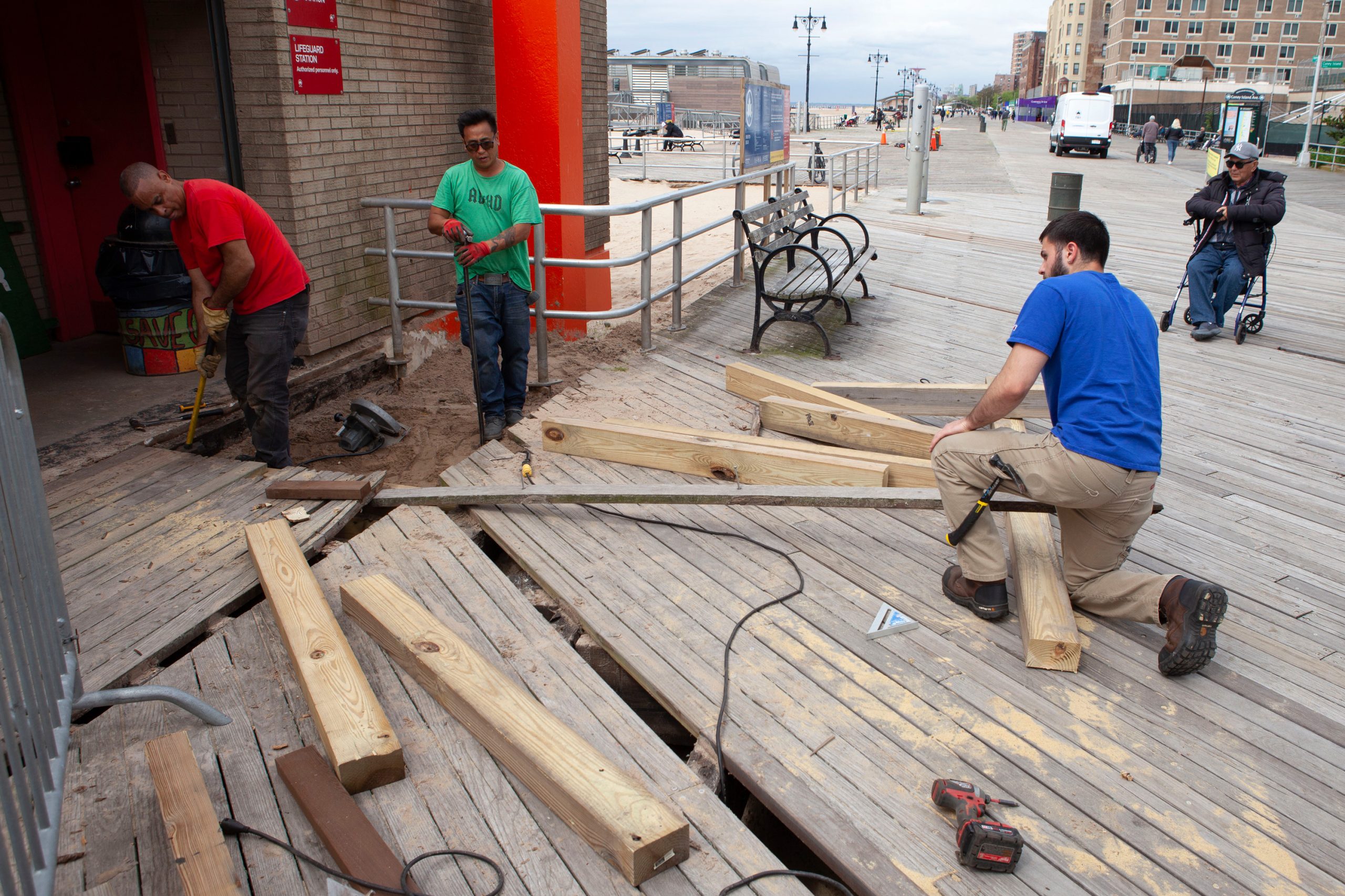 Workers make repairs on the Coney Island boardwalk.