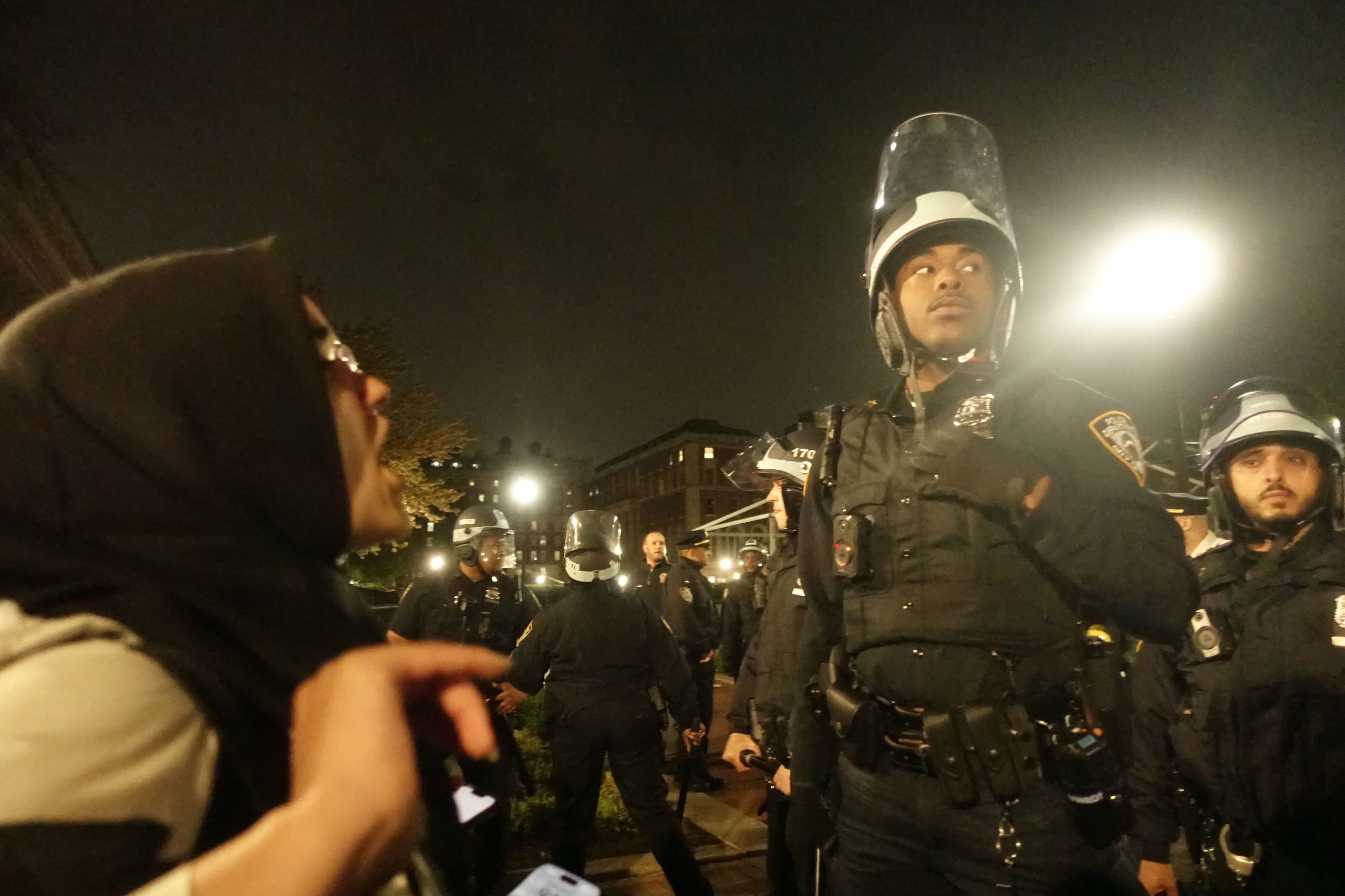 A protester faces off against an NYPD officer on the campus of Columbia University, April 30, 2024.