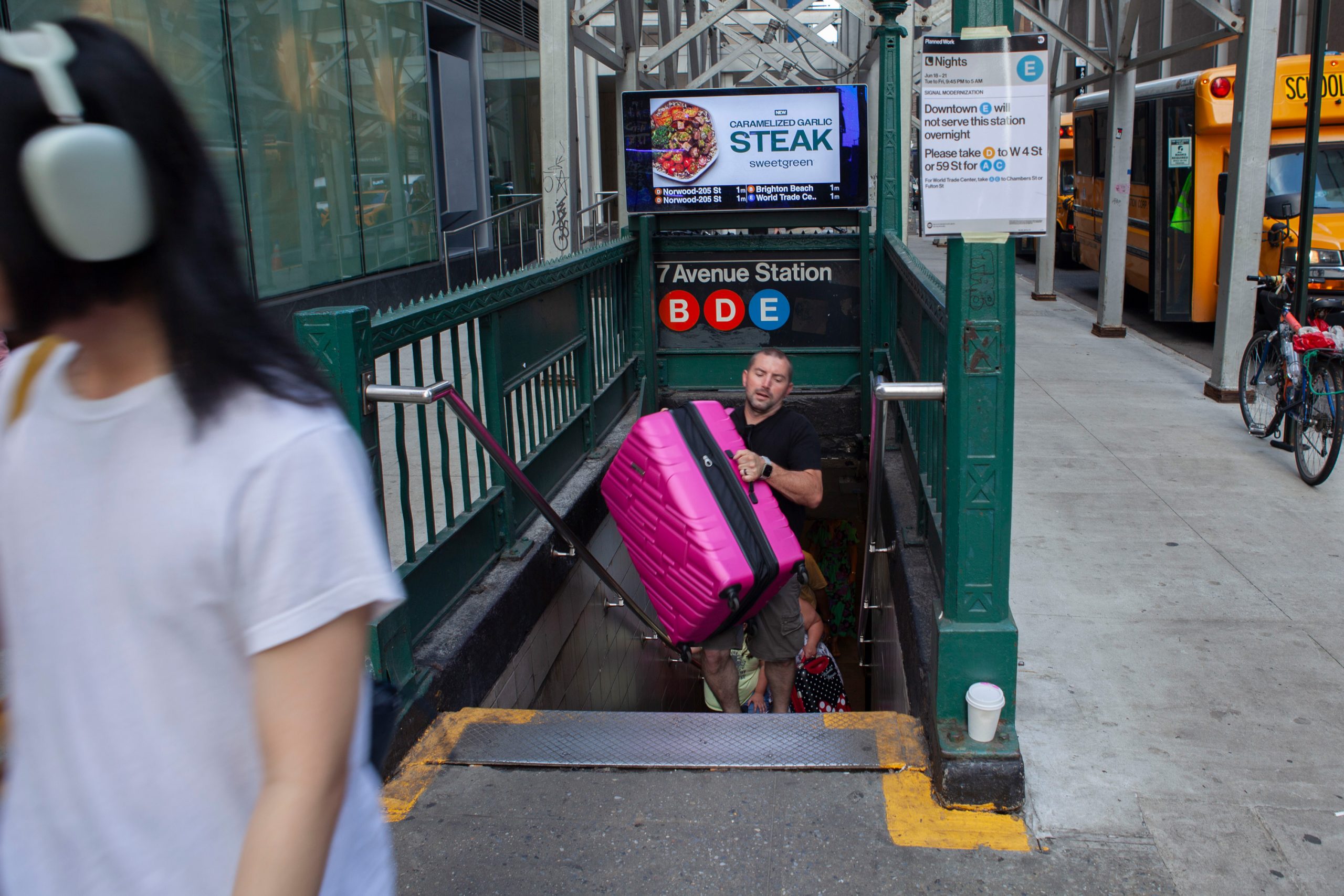 People carry bags up stairs at a subway station without an elevator.