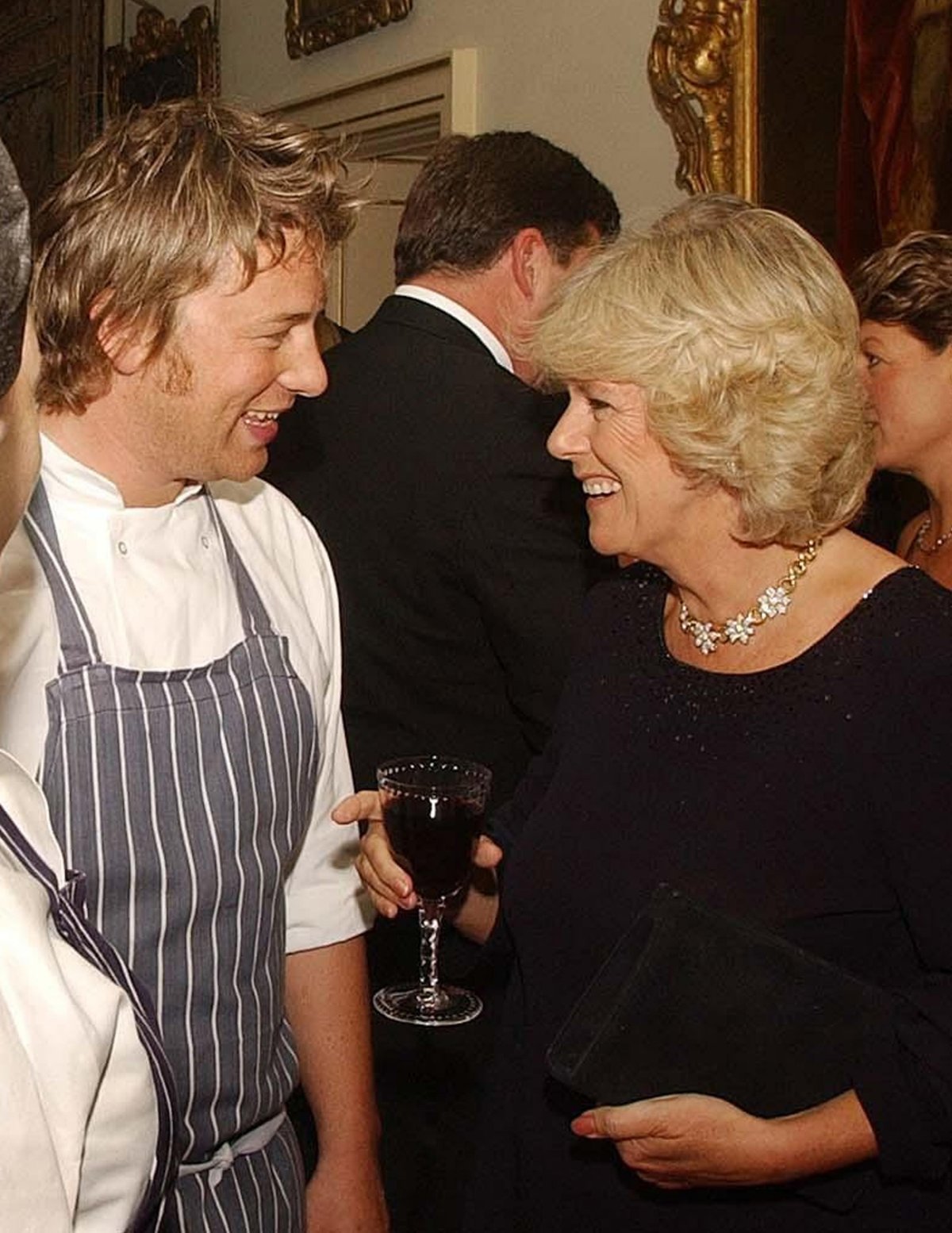 Camilla Parker Bowles, with chef Jamie Oliver, attends a dinner at Clarence House in London celebrating innovations in organic food and farming on September 24, 2003 (John Stillwell/PA Images/Alamy)