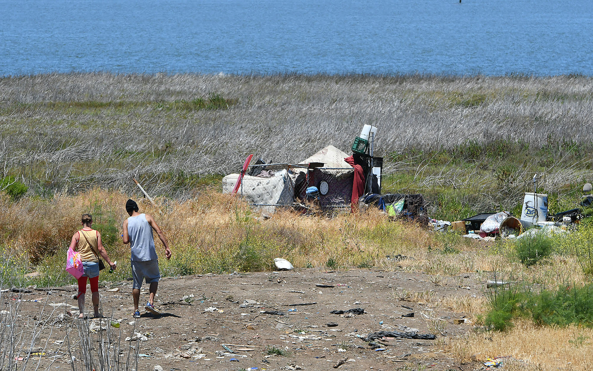 People walk out to an encampment off of Wilson Avenue in Vallejo. (Chris Riley--Times-Herald)
