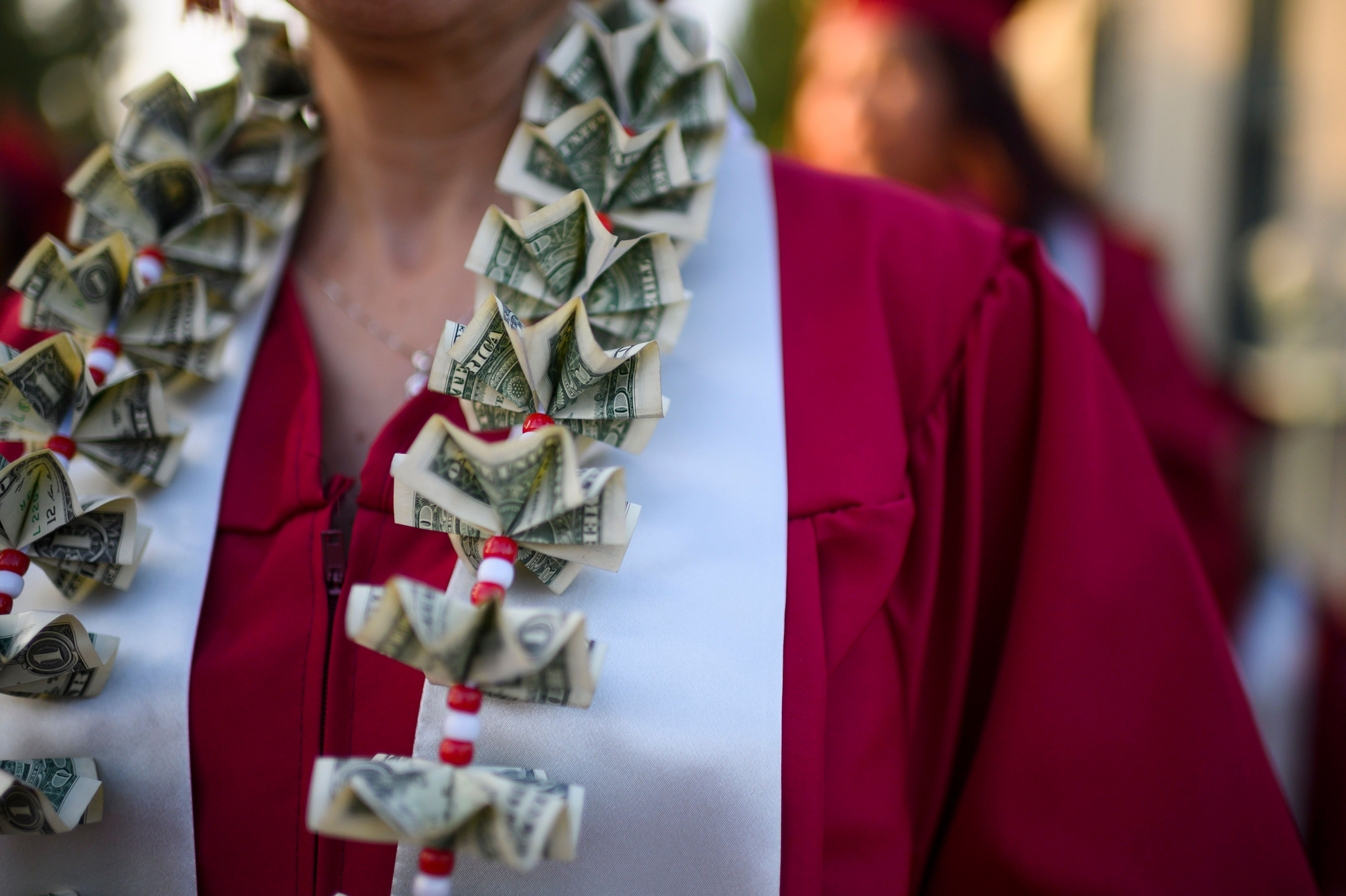 A graduating student wears a money lei, a necklace made of US dollar bills, at the Pasadena City College graduation ceremony, June 14, 2019, in Pasadena, California. - With 45 million borrowers owing $1.5 trillion, the student debt crisis in the United States has exploded in recent years and has become a key electoral issue in the run-up to the 2020 presidential elections."Somebody who graduates from a public university this year is expected to have over $35,000 in student loan debt on average," said Cody Hounanian, program director of Student Debt Crisis, a California NGO that assists students and is fighting for reforms. (Photo by Robyn Beck / AFP) (Photo credit should read ROBYN BECK/AFP via Getty Images)
