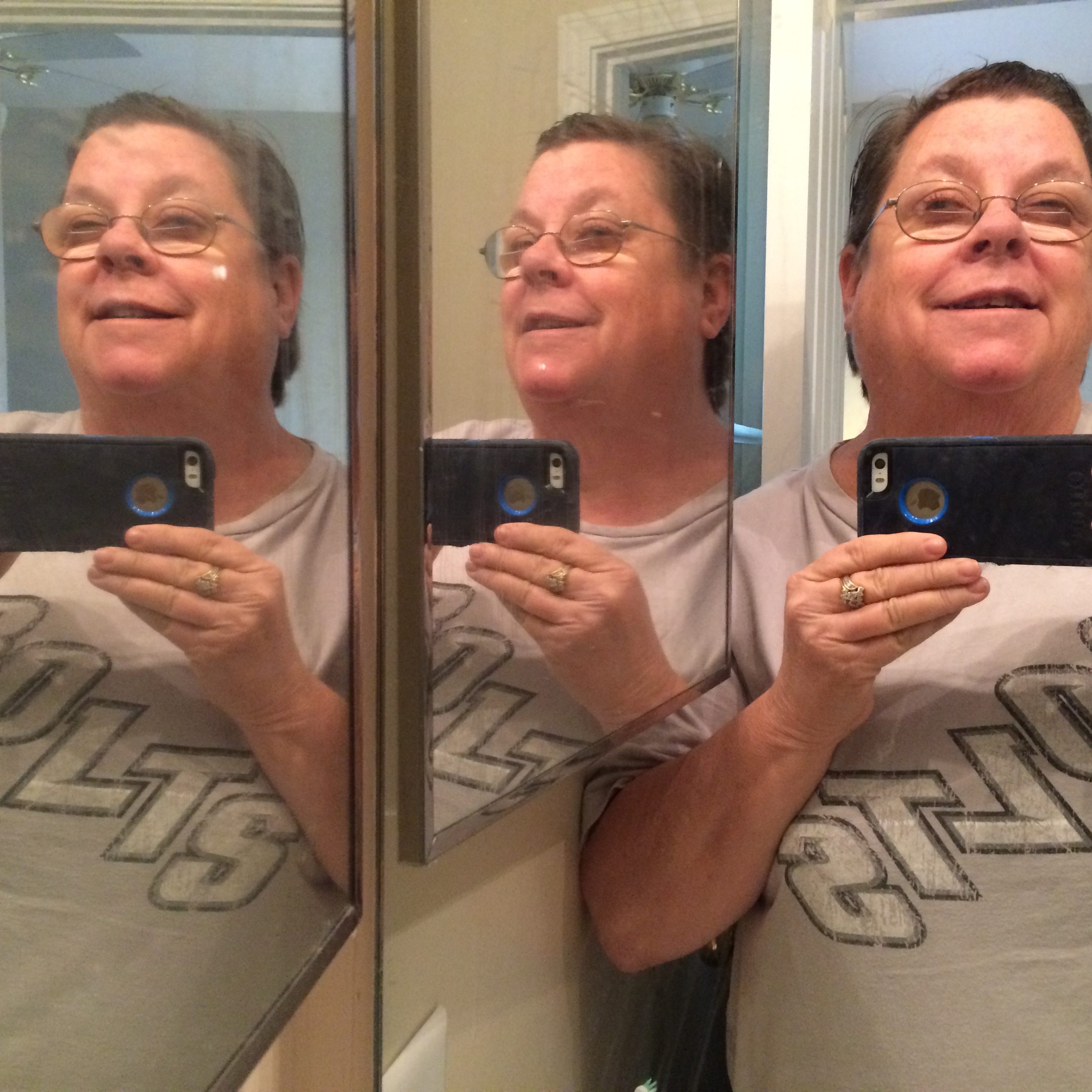 Three faces in the bathroom mirrors.