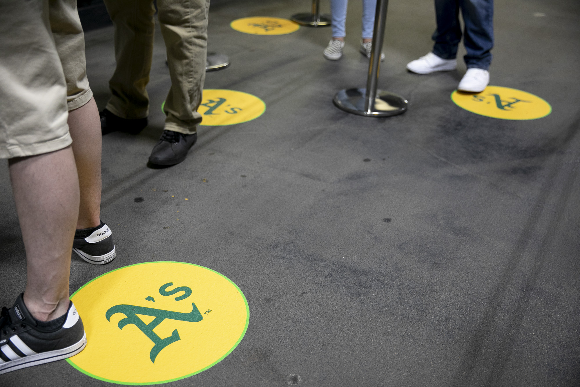 Fans socially distance as they wait in line to pick up orders at a concessions stand. Many struggled to use the online ordering and payment app which led to lines and delays. Photo by Anne Wernikoff, CalMatters