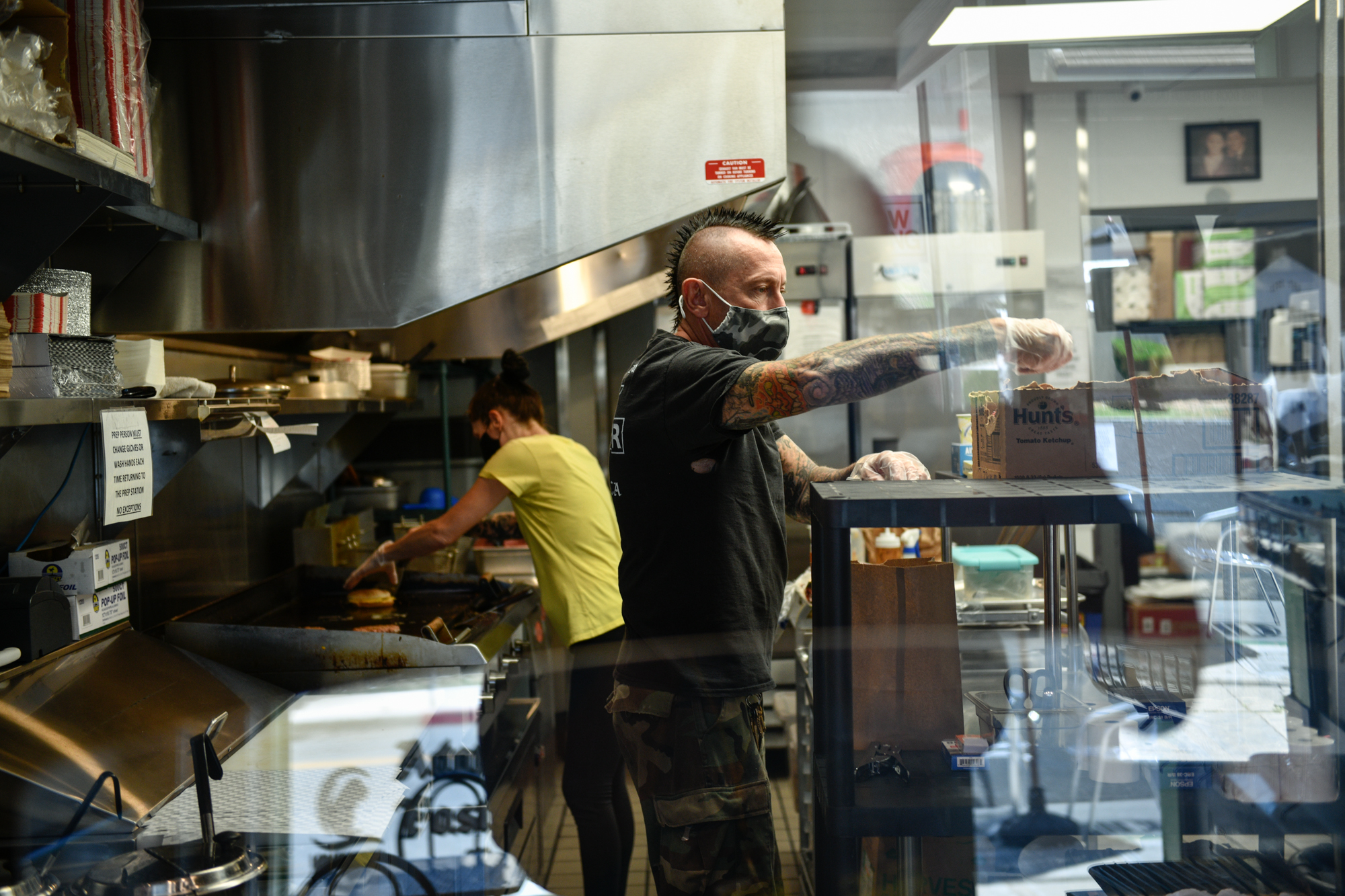 Alex Armstrong, 51 and his wife, Paula Armstrong, 45, prepare pick up orders during lunch hour at their Long Beach restaurant, VBurger, on June 8, 2021. "It's been very challenging for us, but we couldn't back out," said Armstrong of opening mid-pandemic last year. Photo by Pablo Unzueta for CalMatters