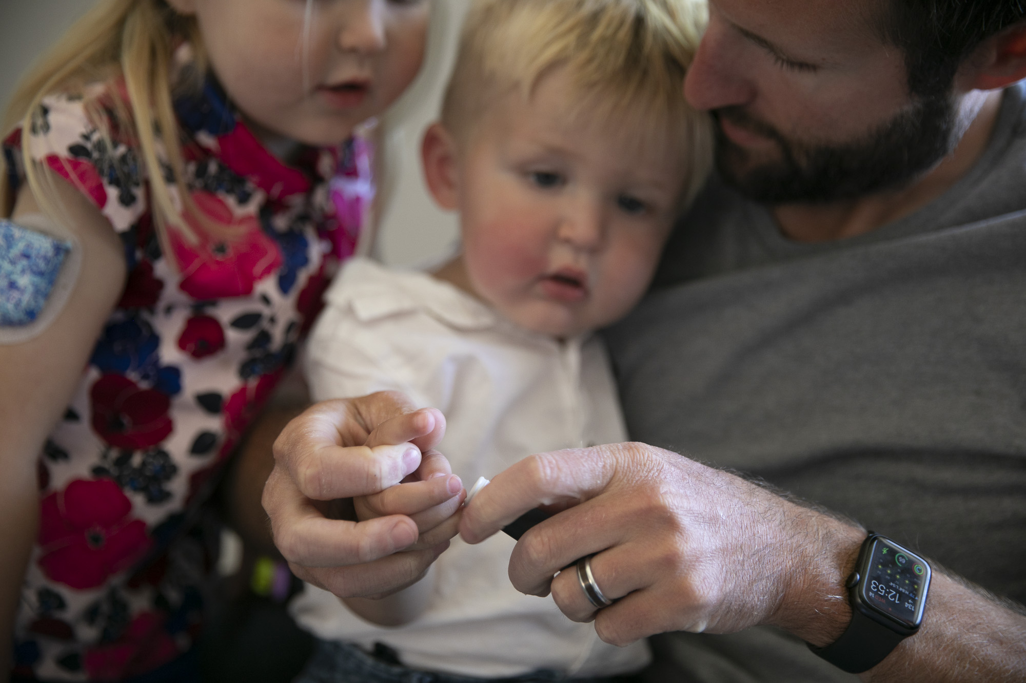 Eleanor, 4, looks on as Jack, 1, has his blood glucose measured by their father, Richard Pollari at their Livermore home. Jack, who was just diagnosed with diabetes several weeks ago, must have his blood tested multiple times a day to monitor his levels but had not yet begun to take insulin. Photo by Anne Wernikoff, CalMatters