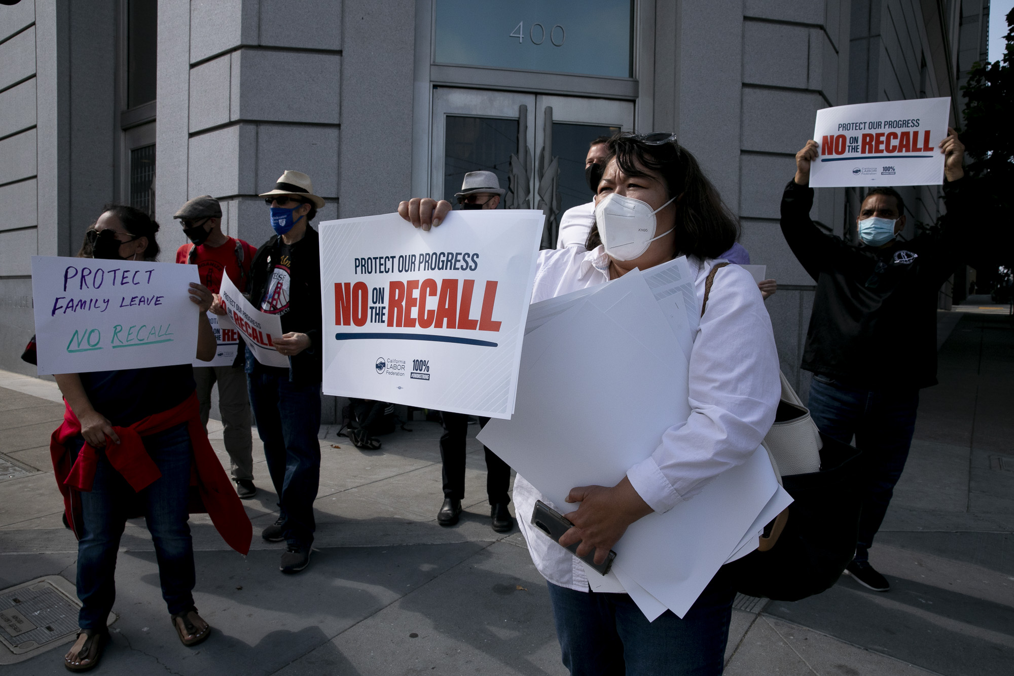 San Francisco Labor Council member Kim Tavaglione, center, participates in a protest against the recall election along with members of various labor groups outside the San Francisco County Superior Court on Aug. 12, 2021. Demonstrators gathered in response to a press event by Rescue California, one of the groups supporting the recall. Photo by Anne Wernikoff, CalMatters