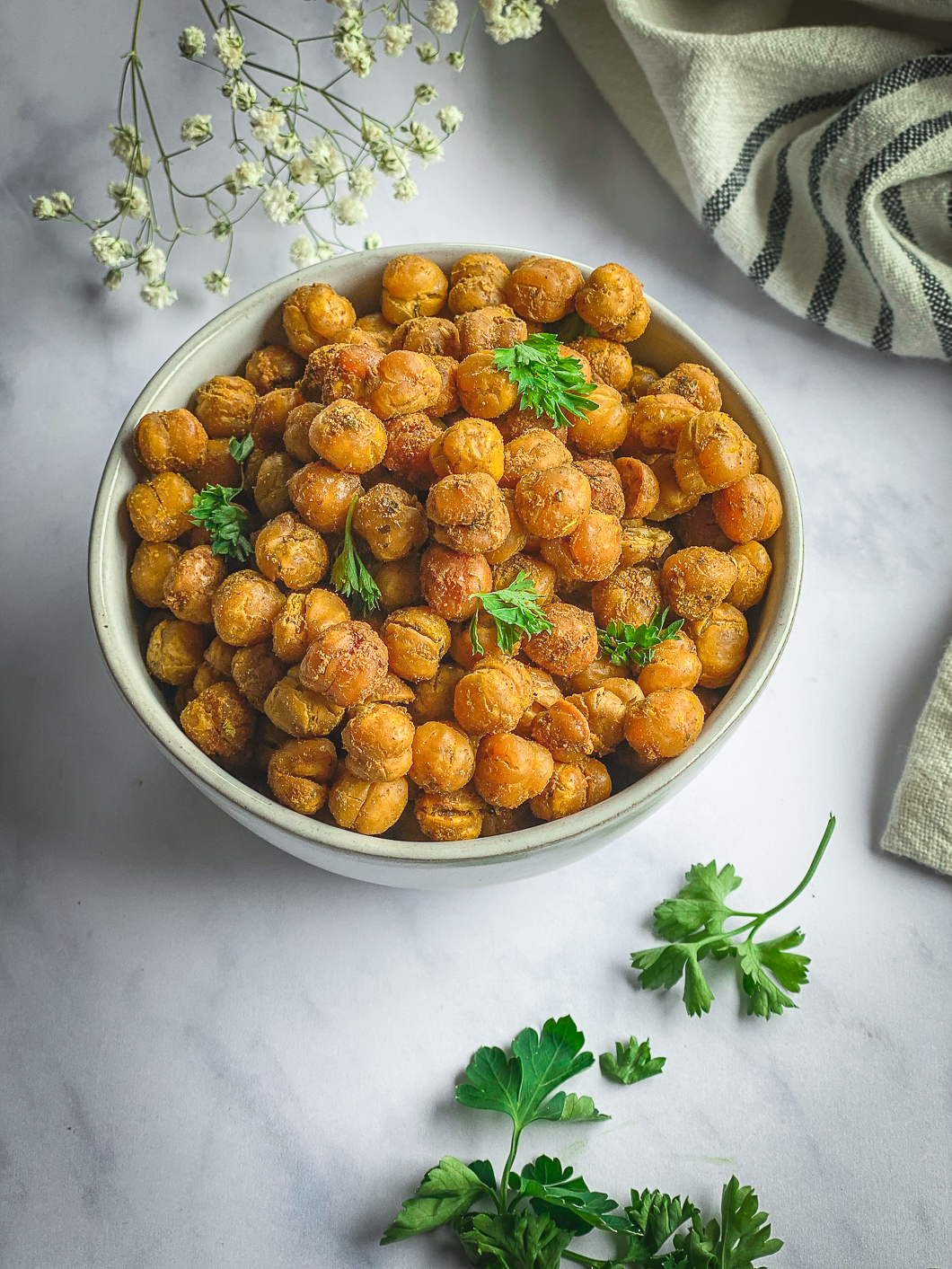 Crispy Roasted Chickpeas in bowl with napkin, and sprinkles with parsley