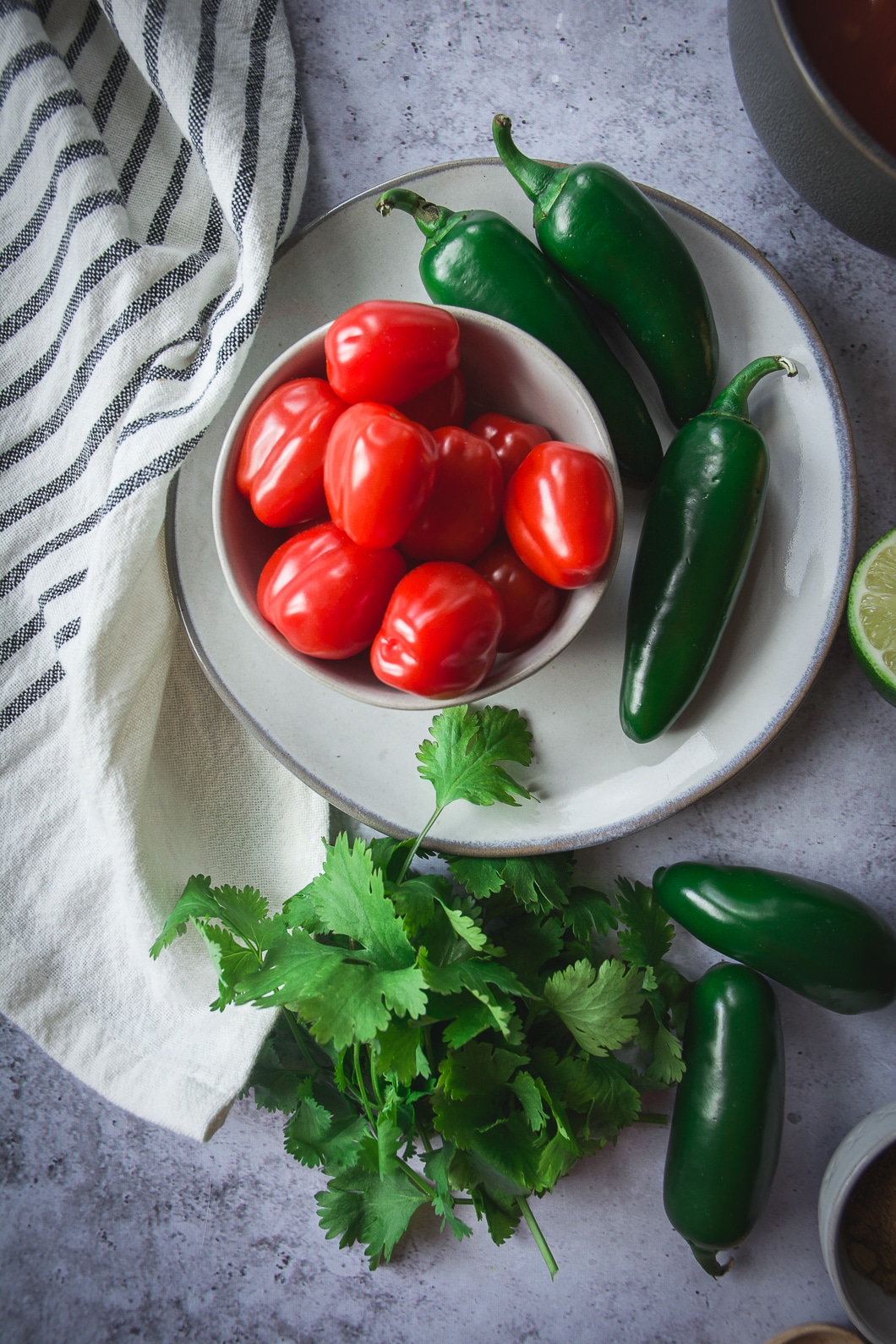 Jalapenos and tomatoes on plate with cilantro lime