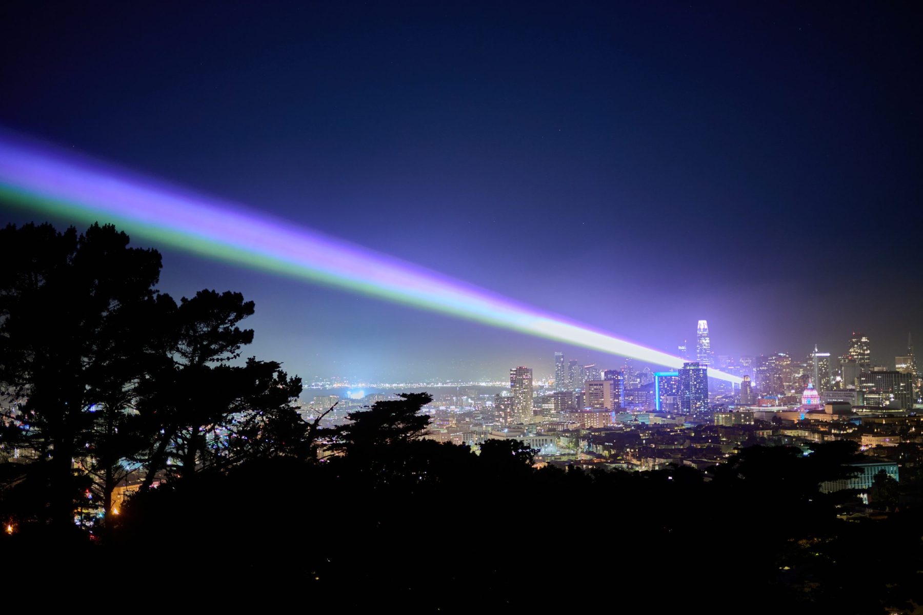 Lasers beaming from the San Francisco skyline into the night sky