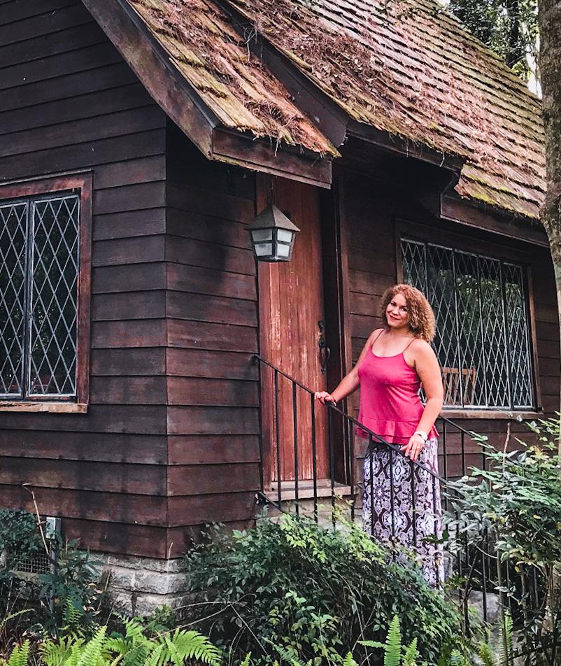 woman posing in front of lichgate on high road fairy tale cottage