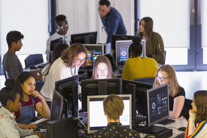 Junior high students and teachers using computers in computer lab