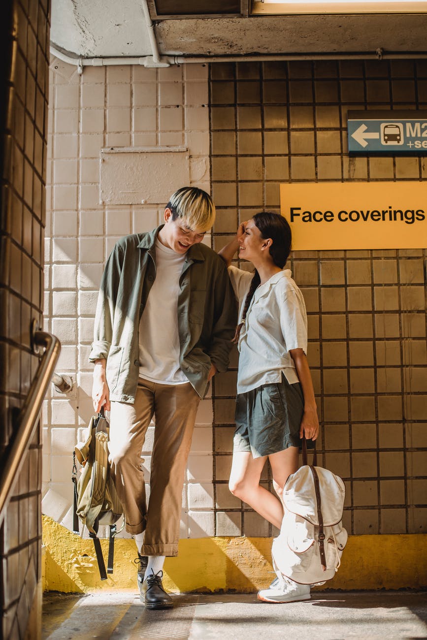 content asian couple standing in roofed crossing and chatting