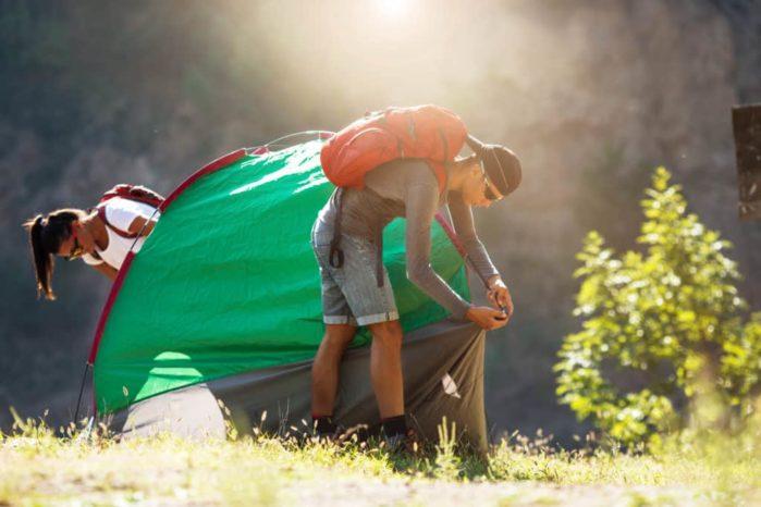 young-couple-setting-up-tent-outdoorshiking-and-camping Camping in the Rain Hacks
