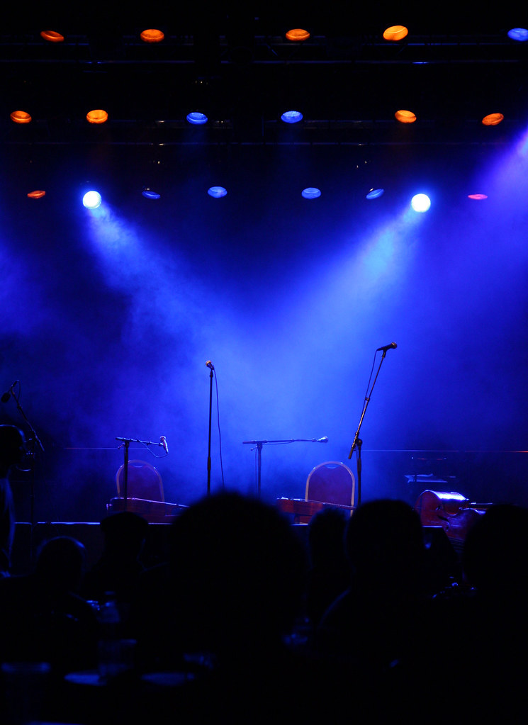 Microphones on unoccupied blue lit stage